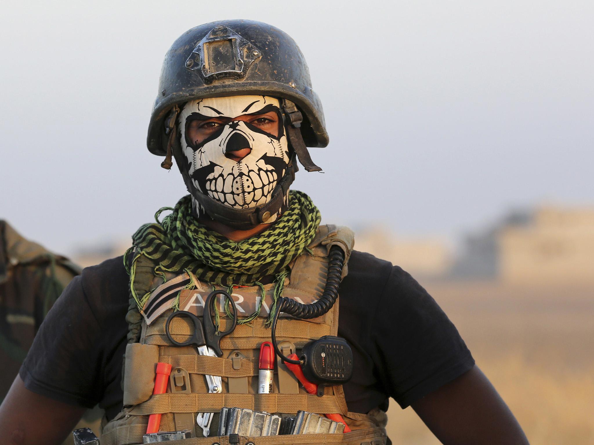 A member of Iraq's elite Special Forces pauses as they advance toward Mosul on Thursday