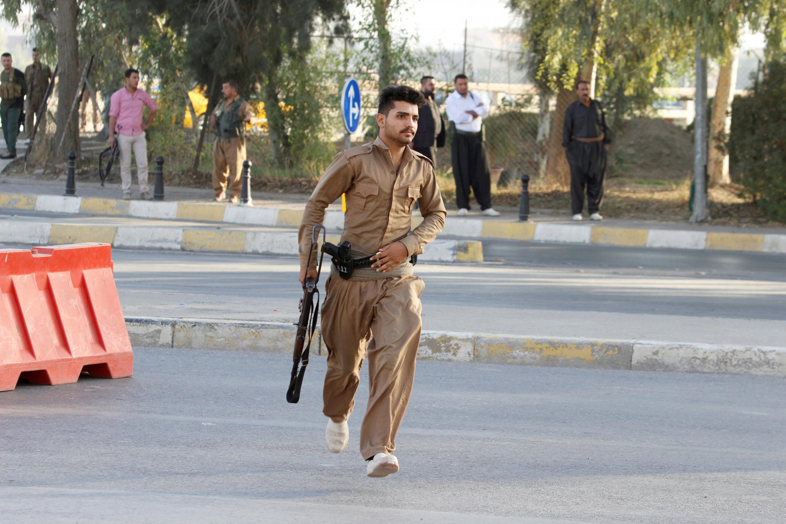 A member of peshmerga forces runs at the site of an attack by Islamic State militants in Kirkuk, Iraq, October 21, 2016