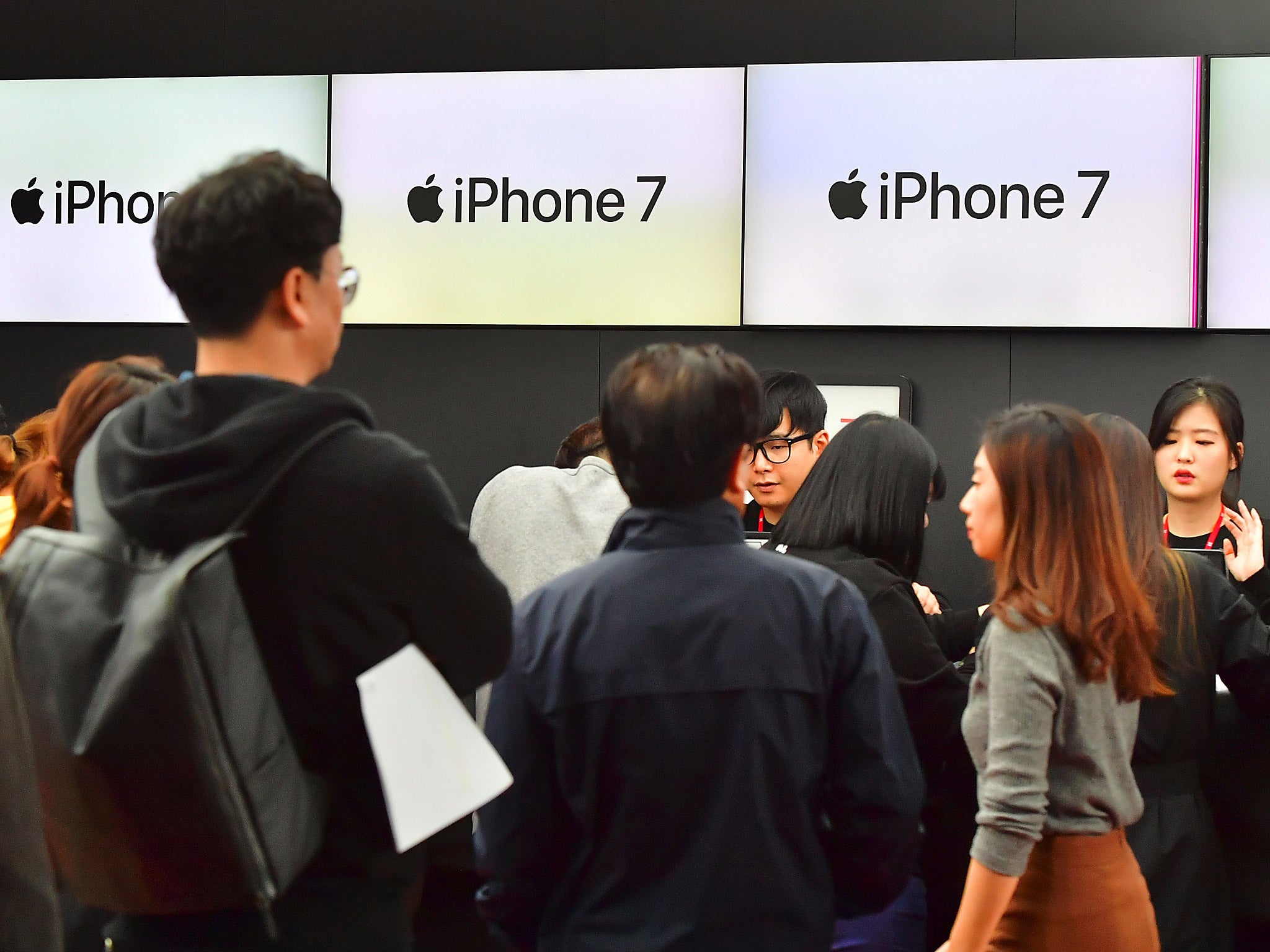 People wait in line to buy new iPhone models at a telecom shop in Seoul, South Korea