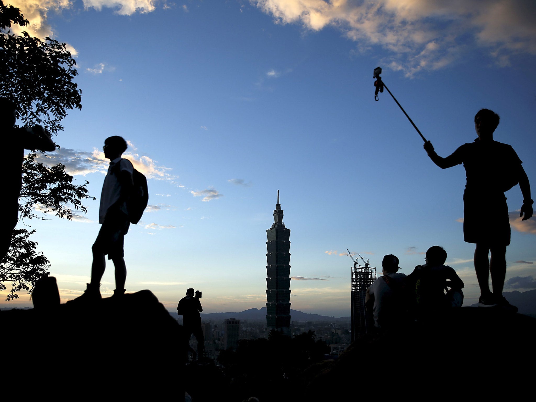 Tourists taking photos at Xiangshan or Elephant Mountain with the Taipei 101 seen in the background in Taipei, Taiwan