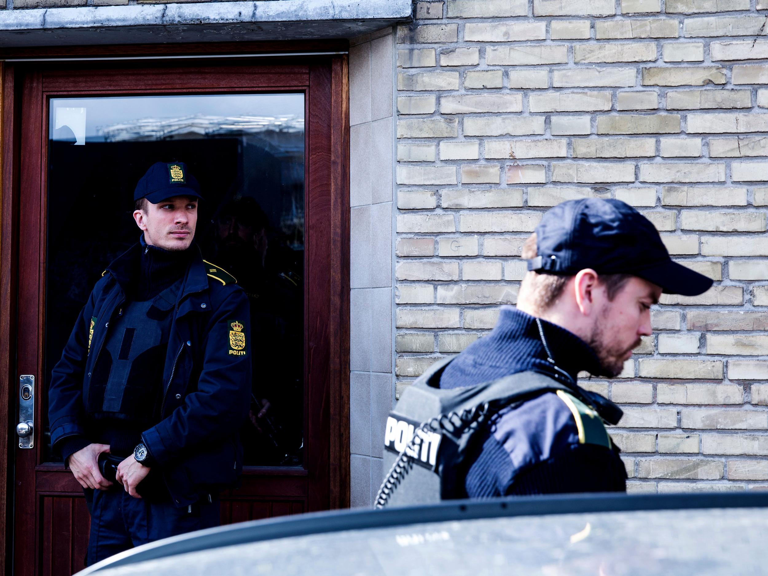 Policemen stand in front of a house in Copenhagen, Denmark