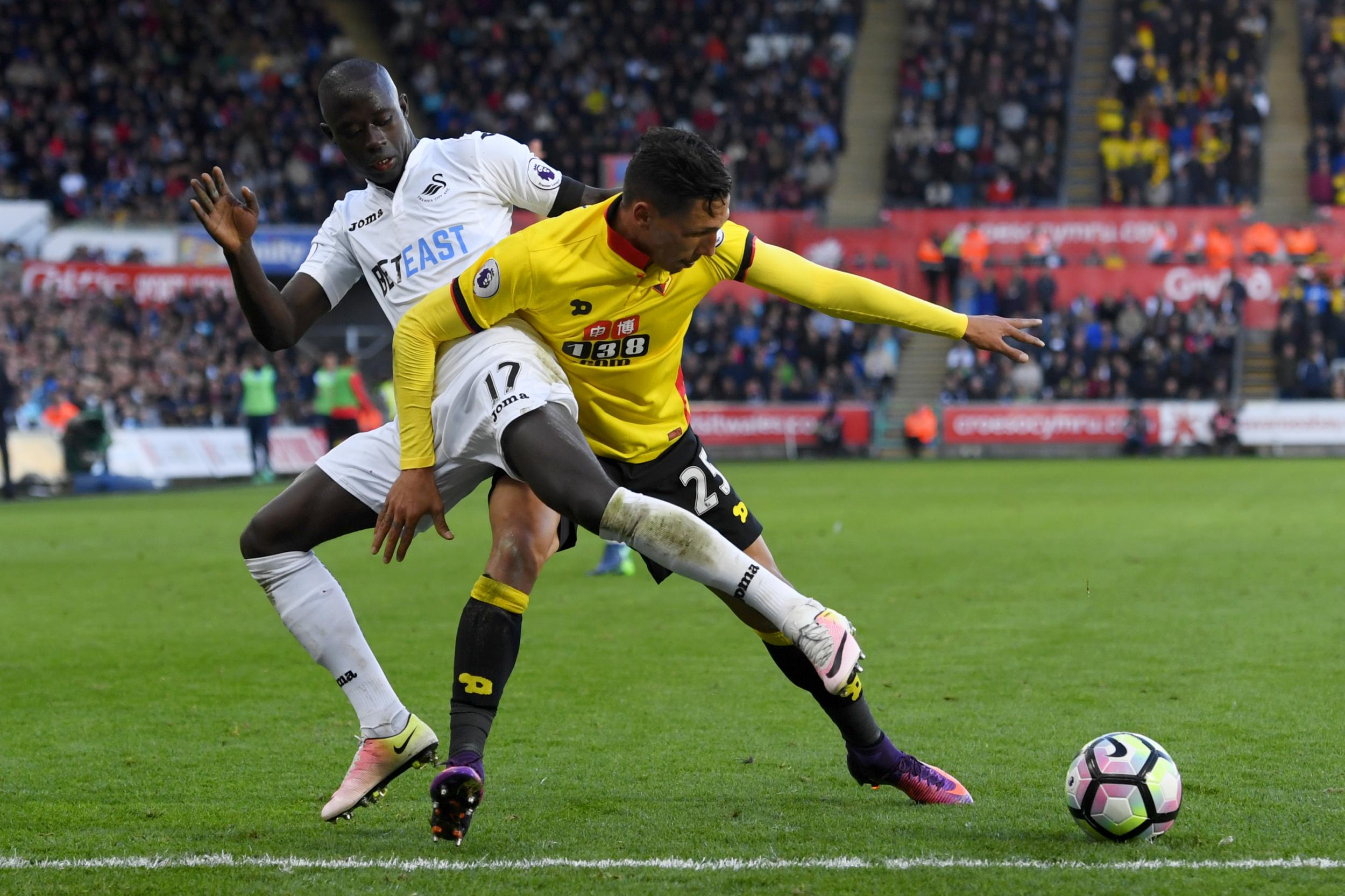 Jose Holebas and Modou Barrow go shoulder-to-shoulder for the ball