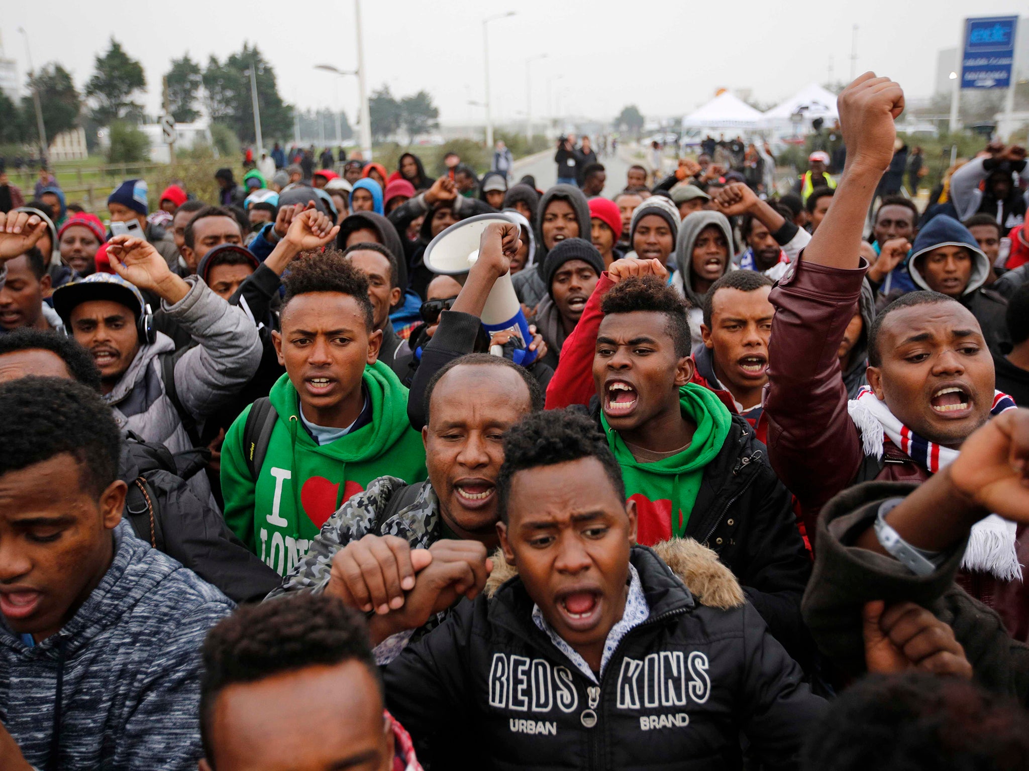 Migrants react as they wait to register at a processing centre in the 'Jungle', Calais