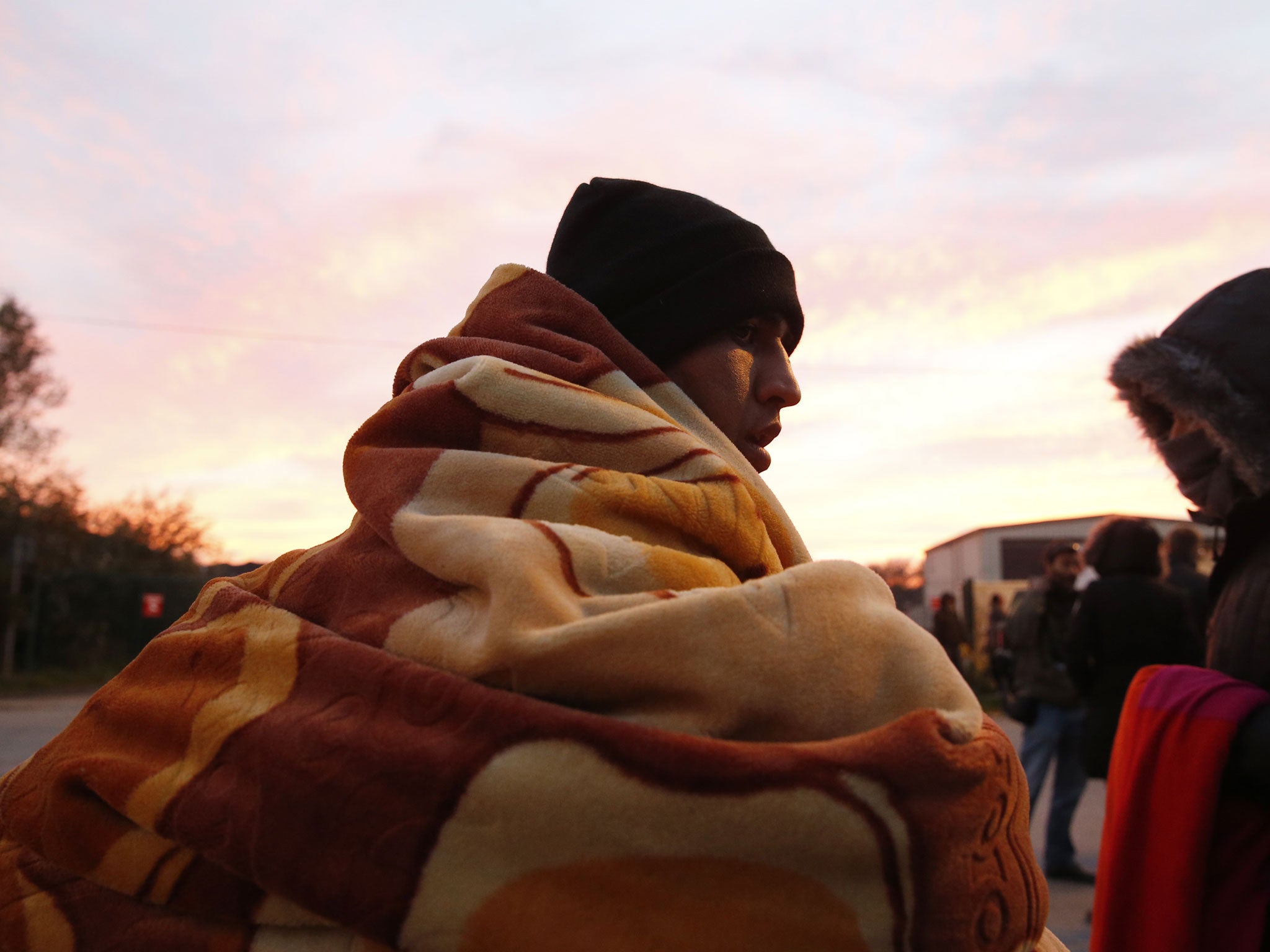 A refugee prepares to spend the night after the dismantlement of the Jungle camp