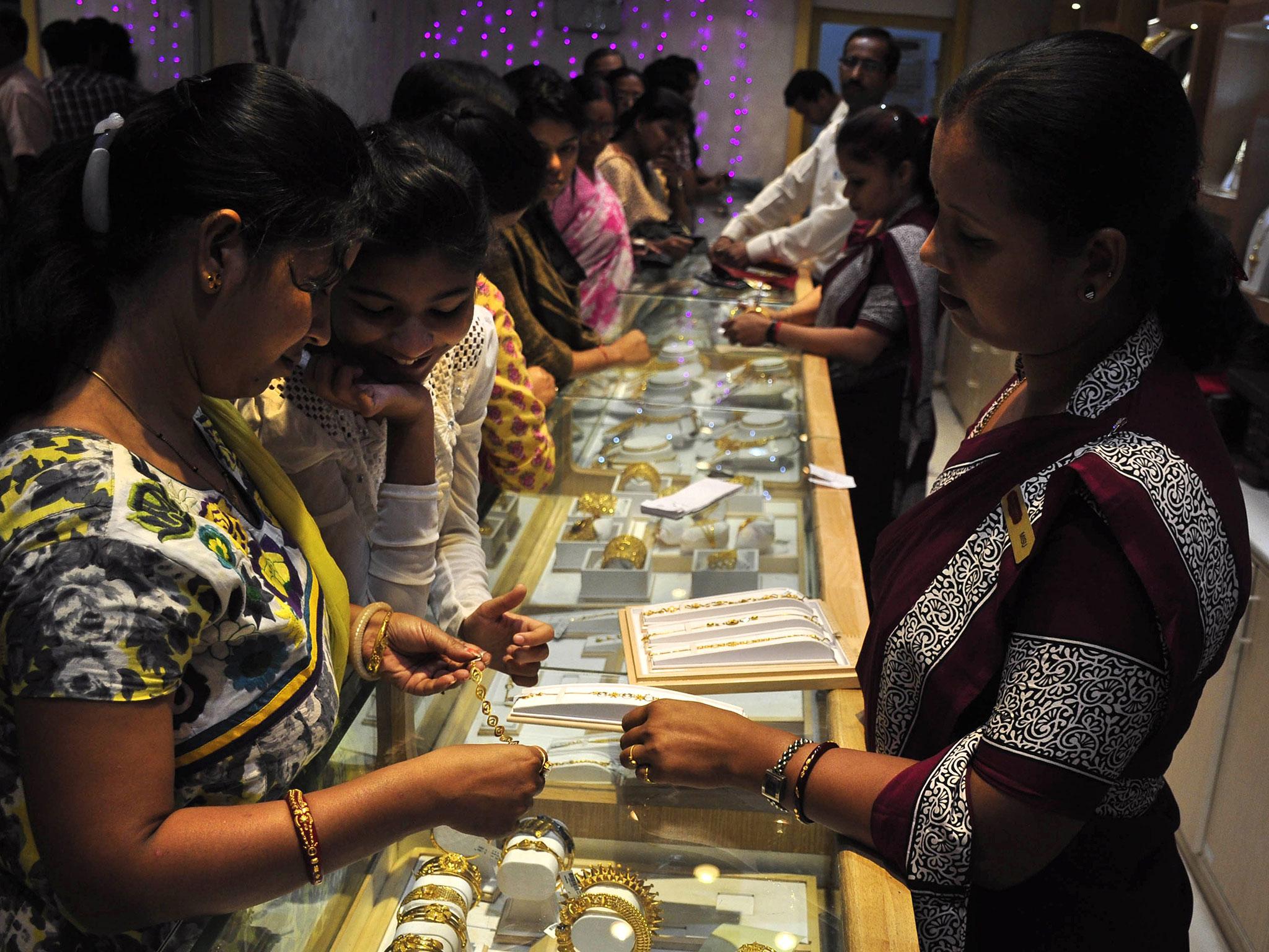 Indian shoppers browse gold jewellery for sale during Dhanteras, ahead of Diwali, in Agartala, the capital of India's northeastern state of Tripura