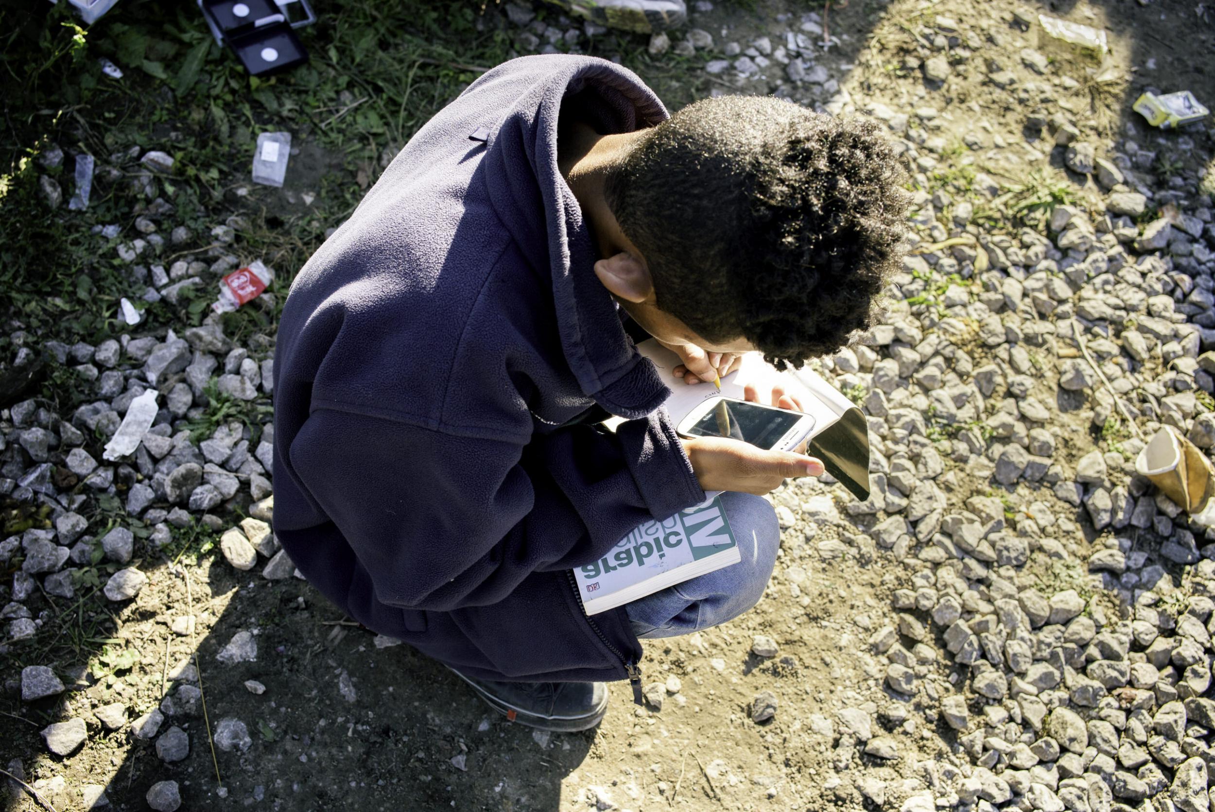 A child doing his homework the morning after having slept rough (Photo: Emily Garthwaite)