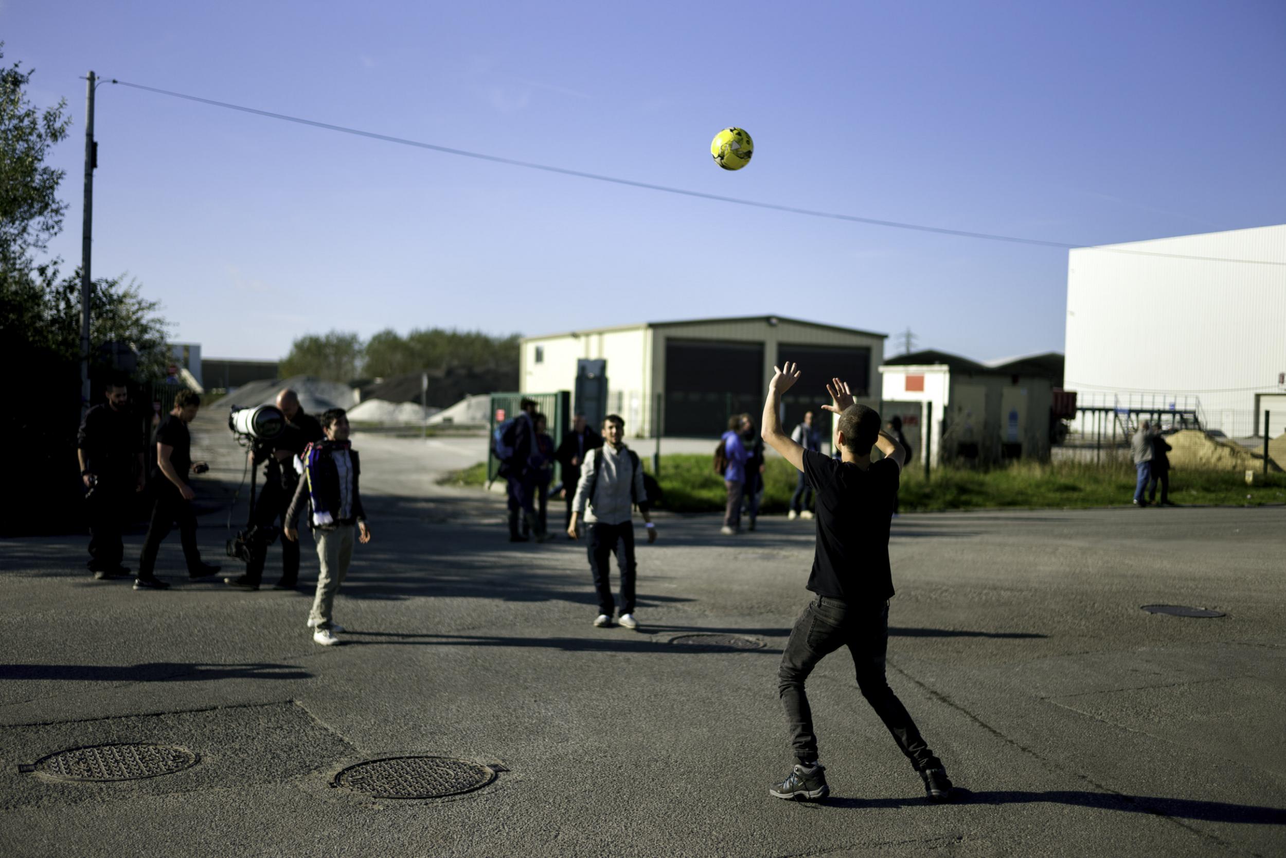 Three minors playing a game waiting for their turn to board (Photo: Alan Schaller)