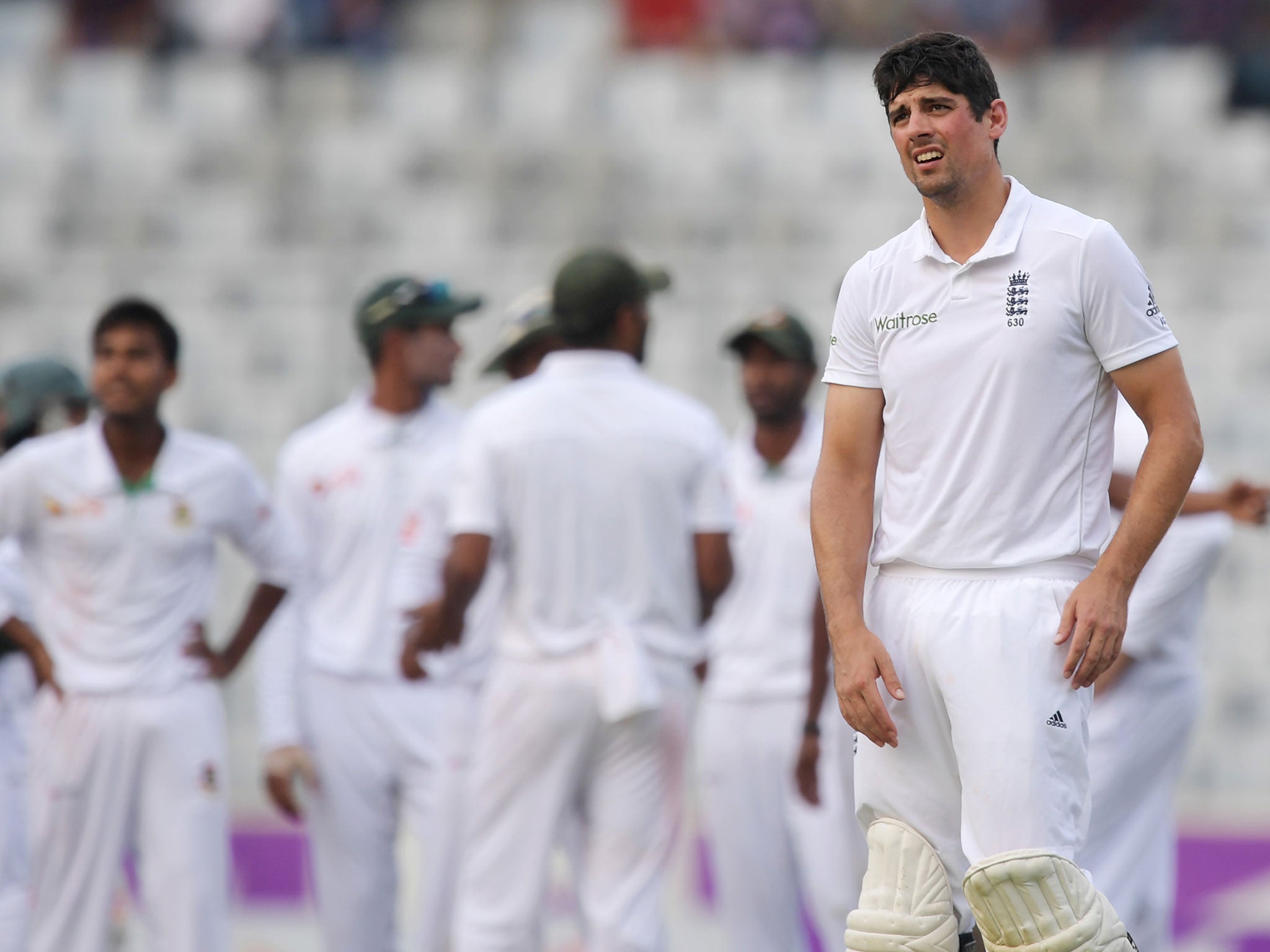 England's Alastair Cook looks on as Mehedi Hasan celebrates the wicket of Gary Ballance with teammates