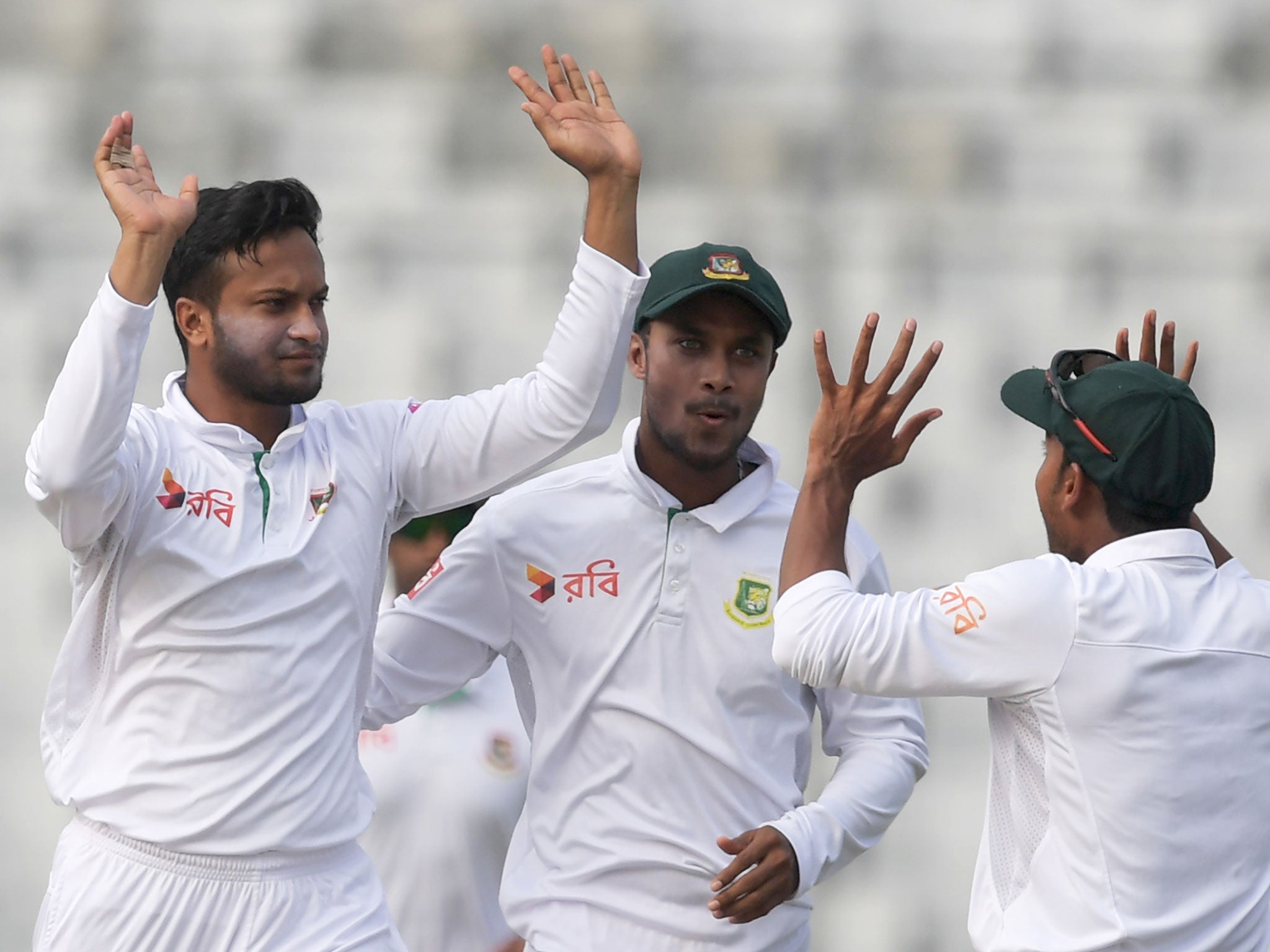 Shakib Al Hasan (L) with teammate Mehedi Hasan (R) and Sabbir Rahman celebrate the wicket of England's Joe Root