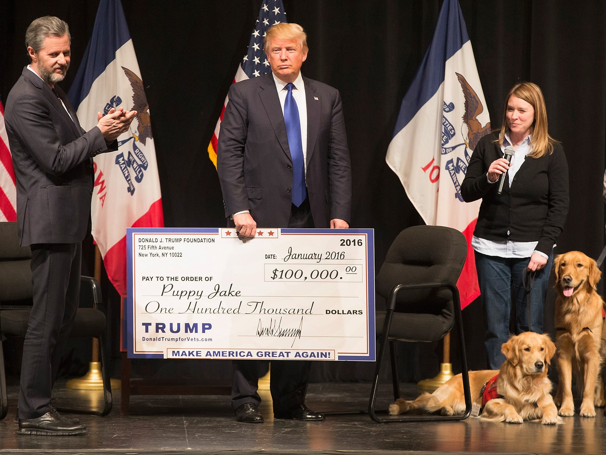 Donald Trump presenting a cheque for $100,000 to a charity that provides dogs for wounded veterans. He gave over $250,000 for the renovation of a fountain outside his Plaza Hotel.