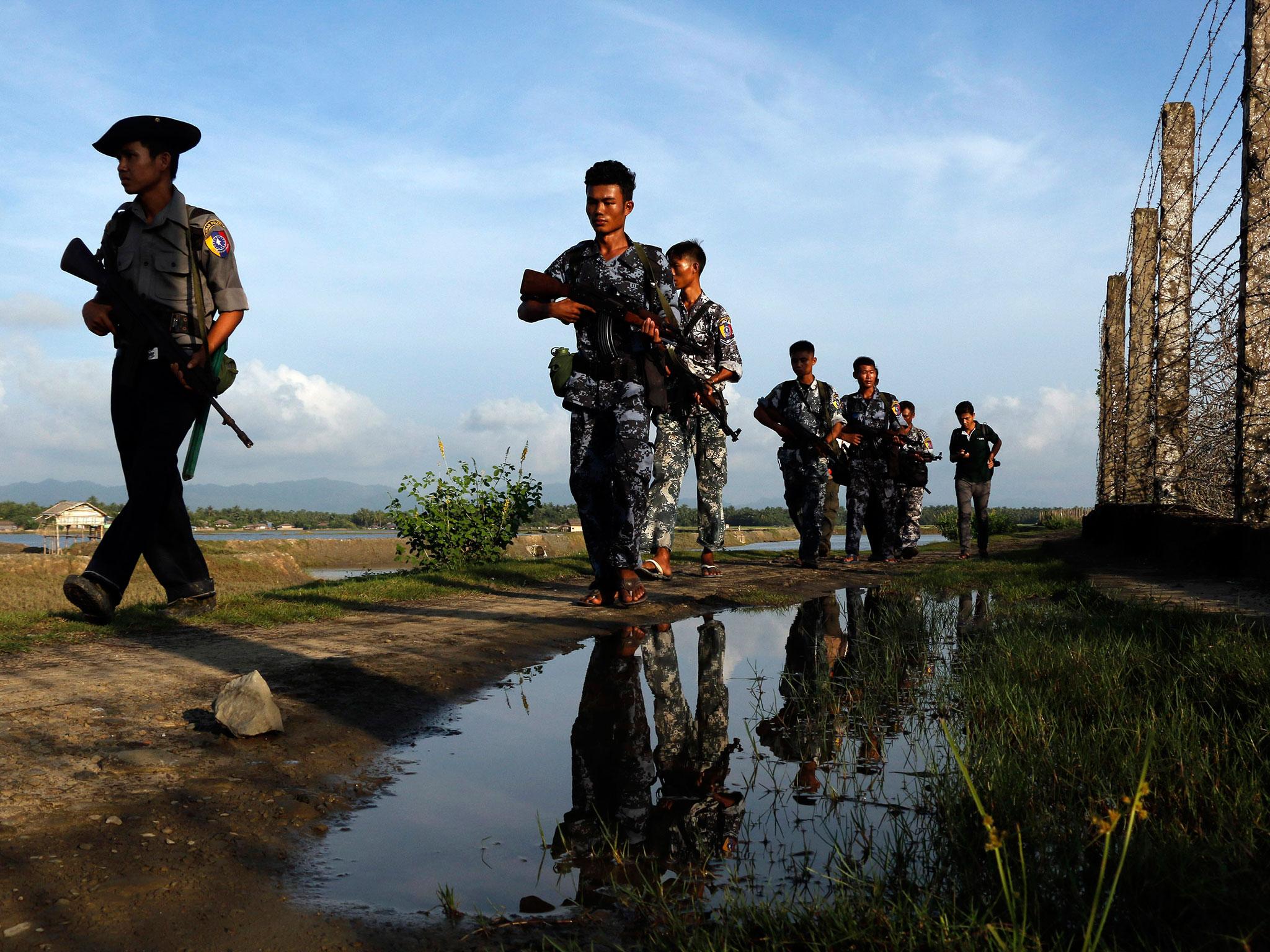 &#13;
Burmese police officers patrol along the border fence between Burma and Bangladesh in Maungdaw, Rakhine State, Friday, 14 October, 2016 &#13;