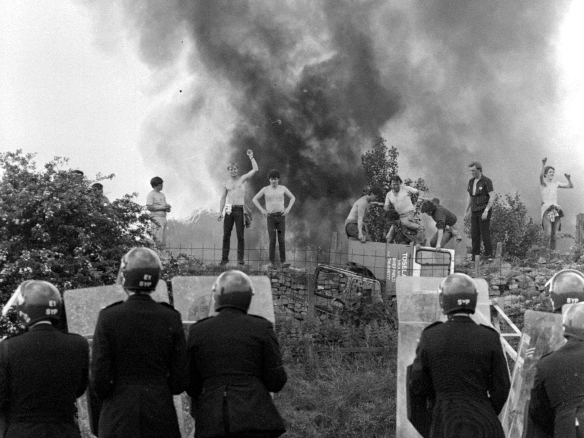 Miners strike - Riot police look on at picketers and burning cars at the Orgreave coking works in Yorkshire in June, 1984