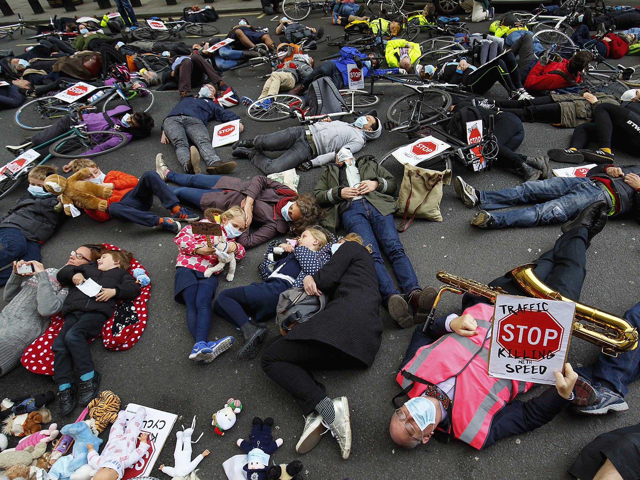 Protesters stage a die-in protest with gas masks and teddy bears at an anti-pollution rally in London
