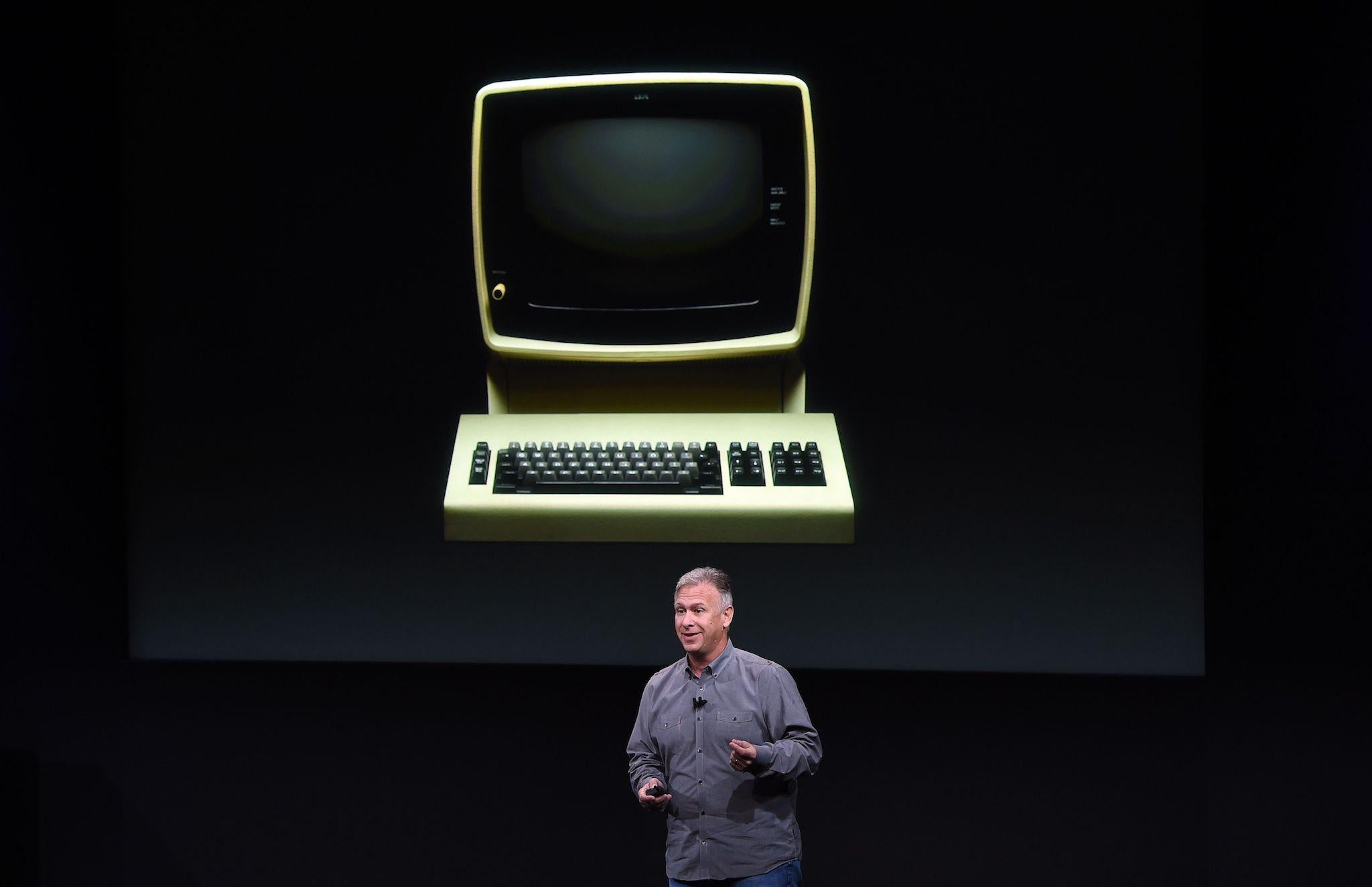 Senior Vice President of Worldwide Marketing Phil Schiller speaks in front of a projection of an old IBM 3279 terminal during a product launch event at Apple headquarters in Cupertino, California on October 27, 2016