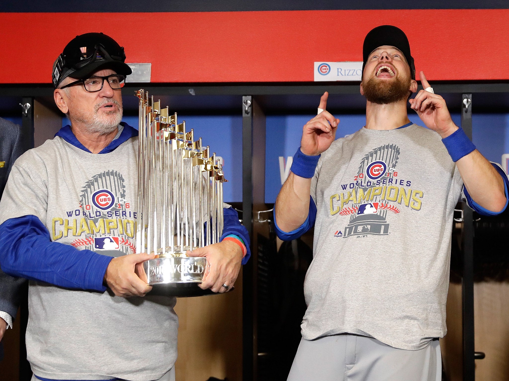 Cubs manager Joe Maddon holds the Commissioners' Trophy while Ben Zobrist celebrates