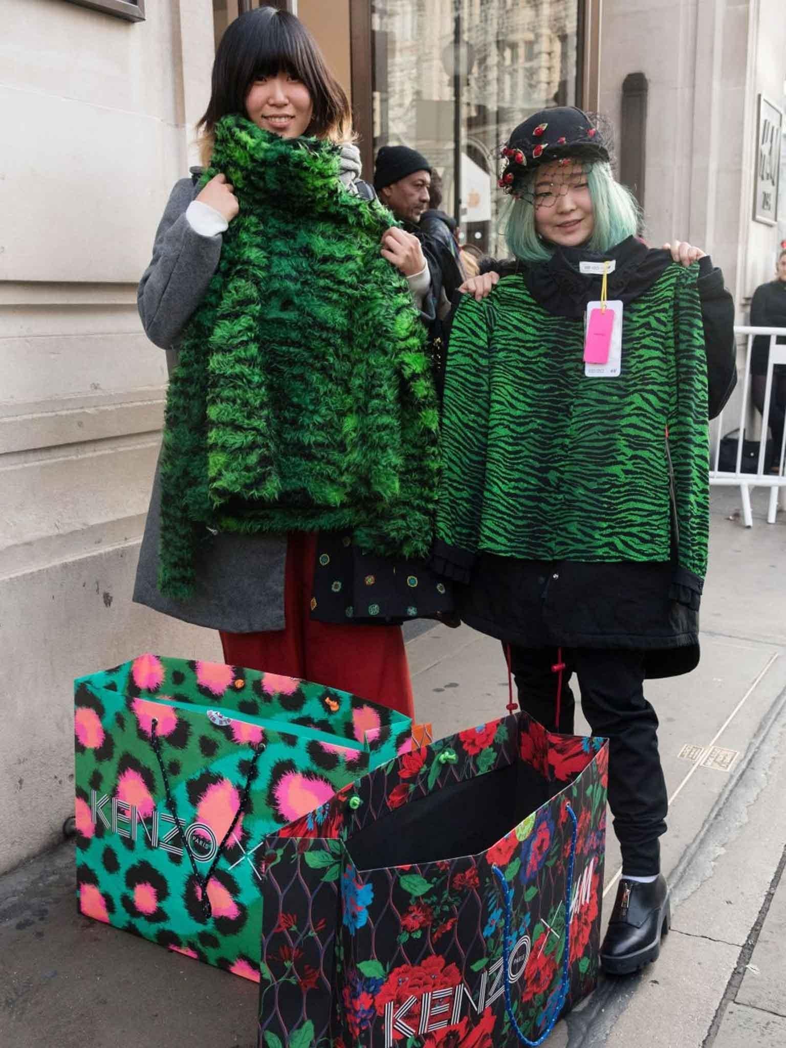 Customers show their bought clothes and shopping bags leaving the Regent Street store (Ray Tang/REX)