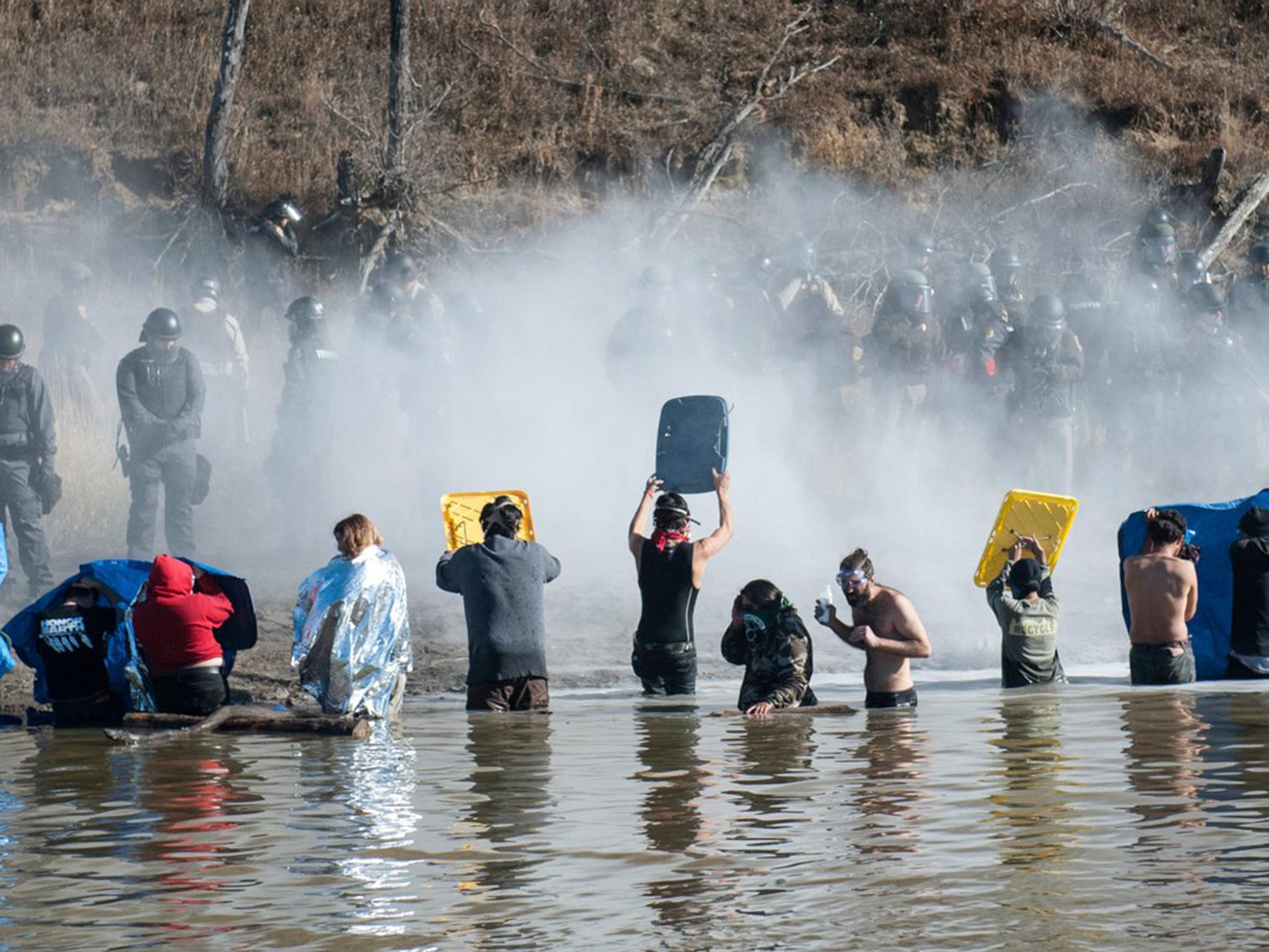 Police use pepper spray against people standing in the water