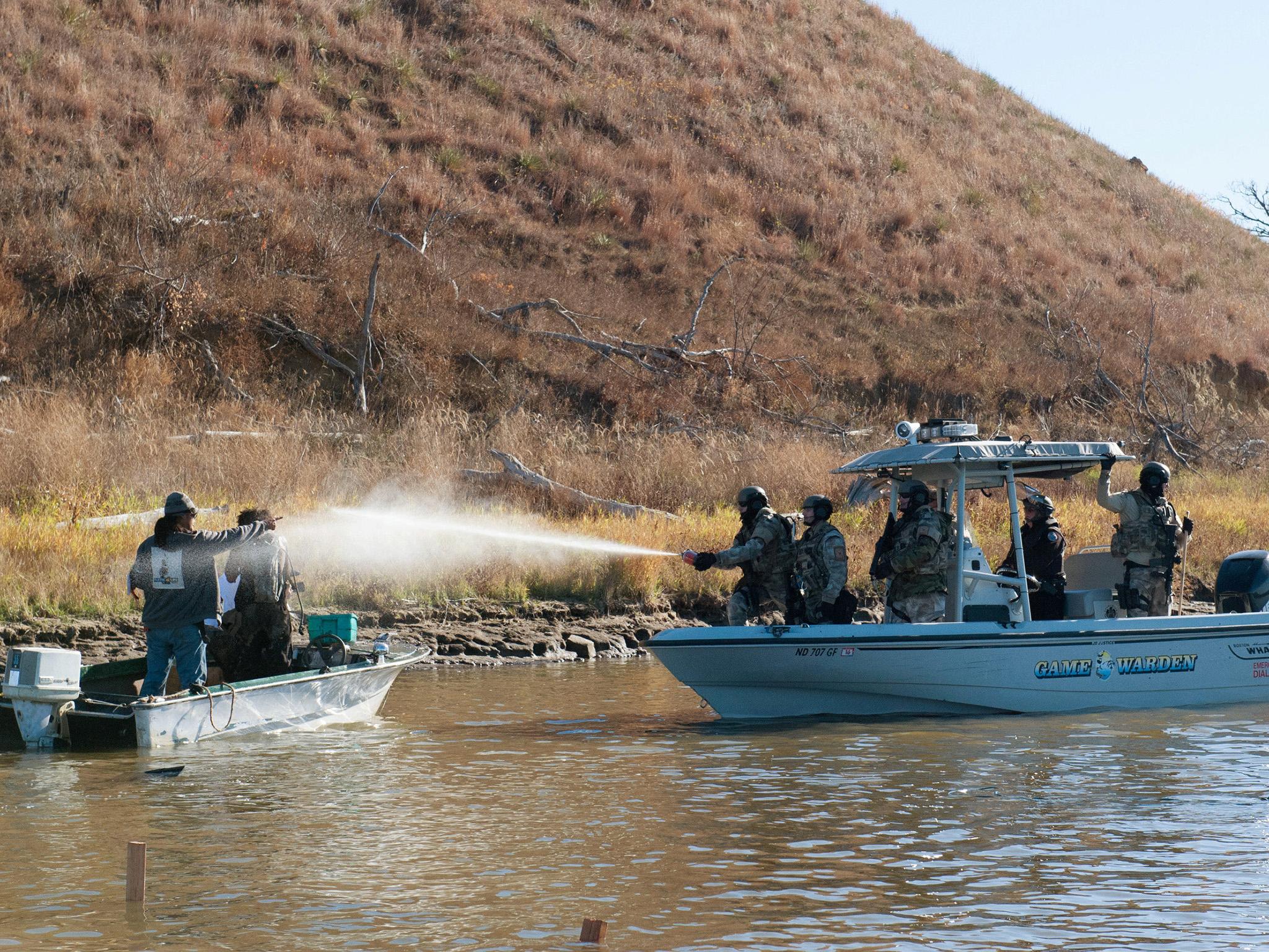 Police use pepper spray against protesters in a boat during a protest against the building of a pipeline