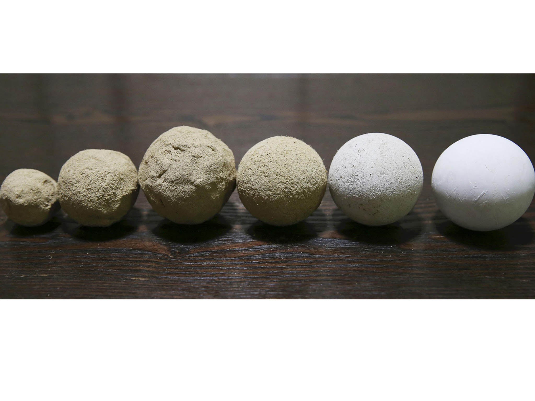 Stages in the creation of dorodango are shown from left to right, with the balls gradually becoming smoother