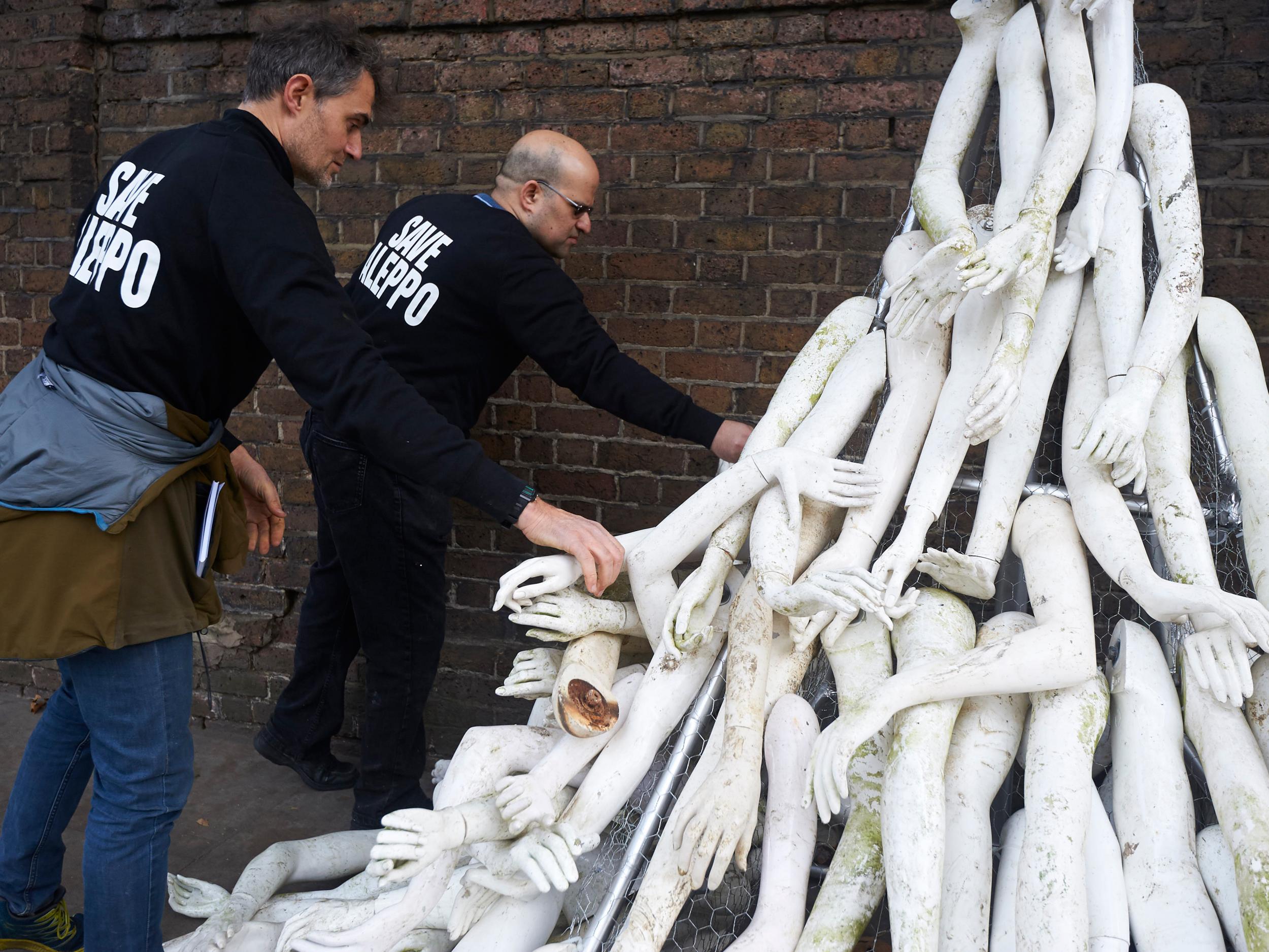 Campaigners create a structure made from white mannequin limbs outside the Russian Embassy