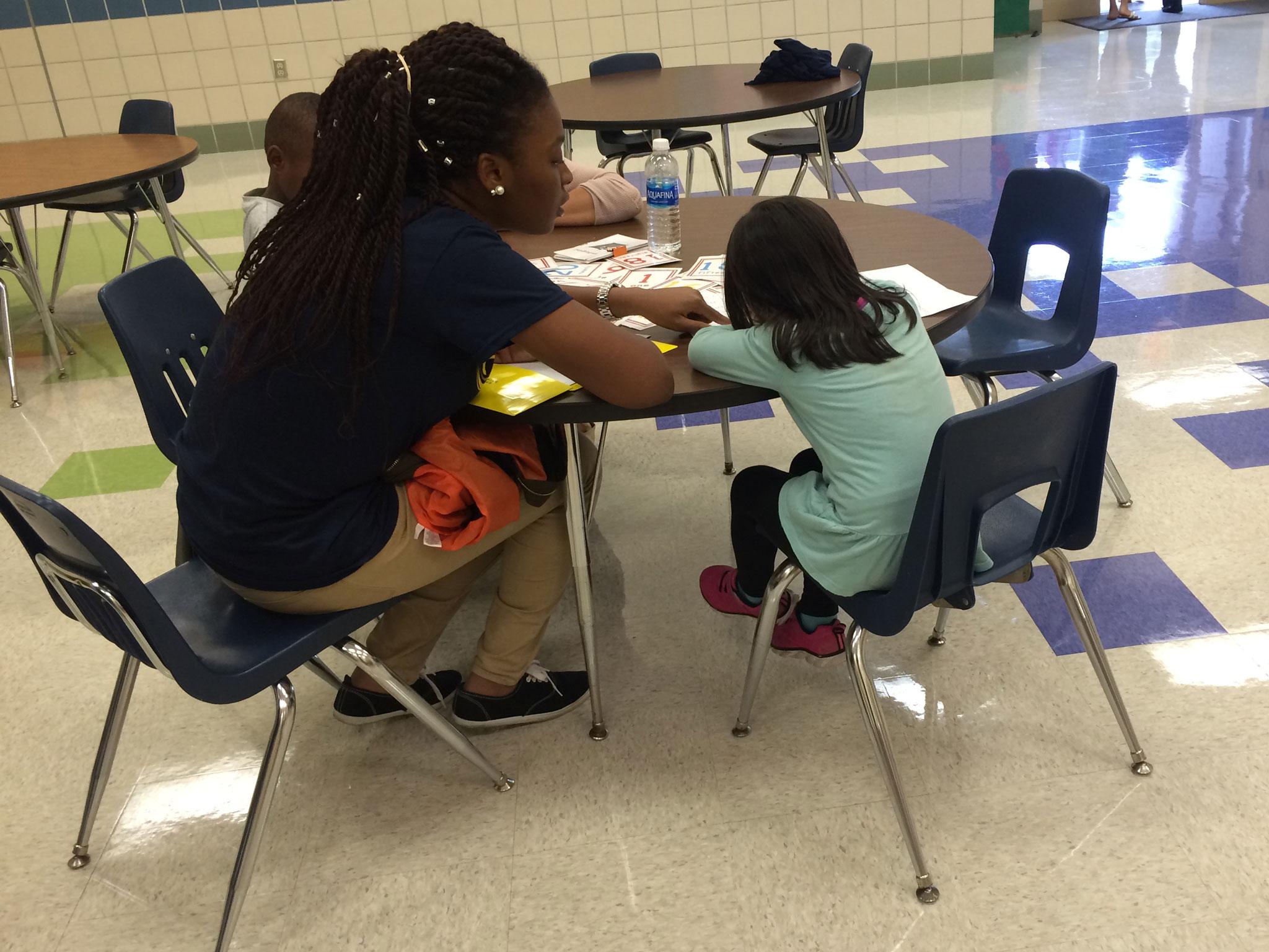 A work-study tutor gives a lesson to students from Syria and Somalia