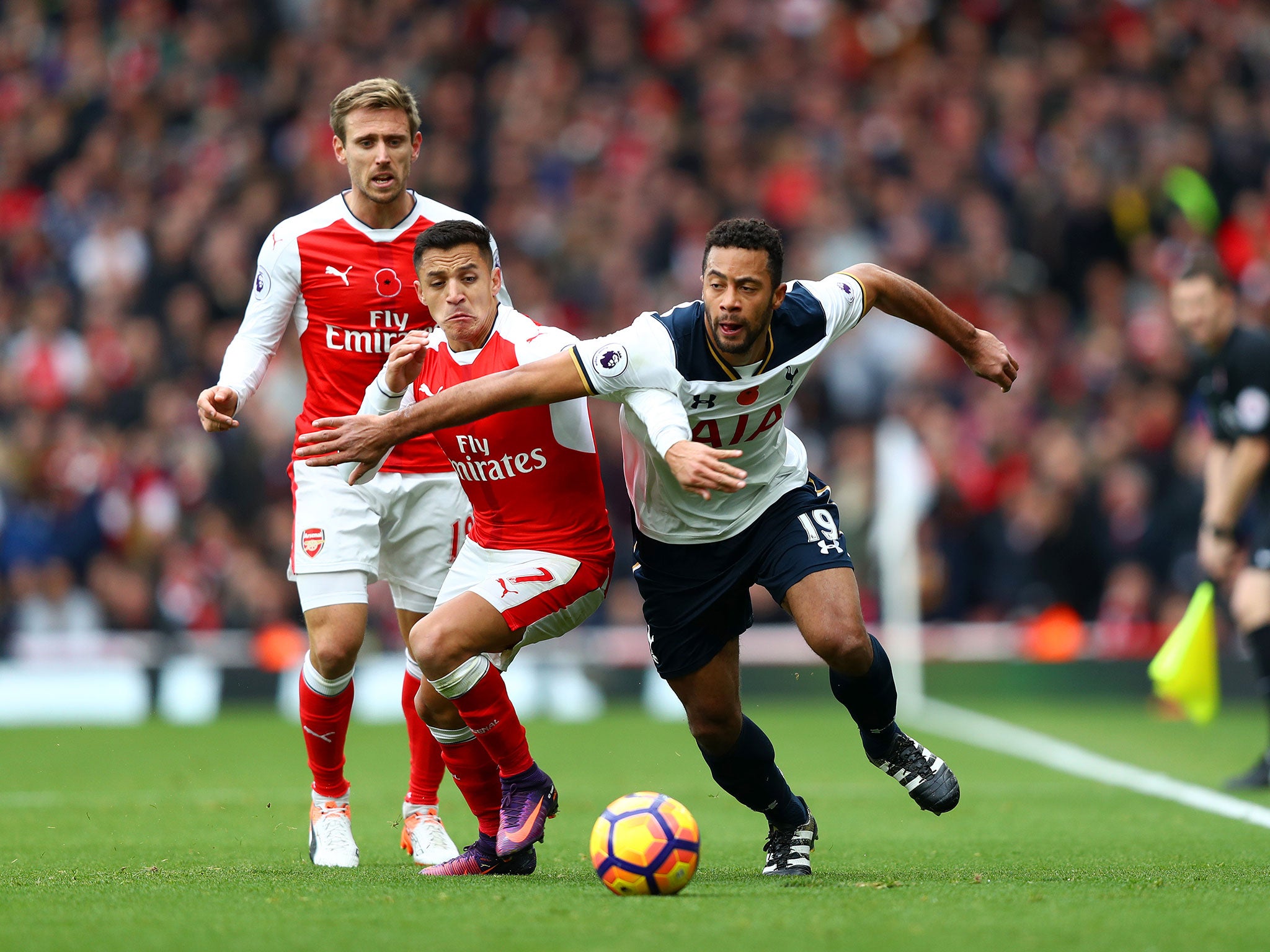 Mousa Dembele and Alexis Sanchez vie for the ball early on in the game