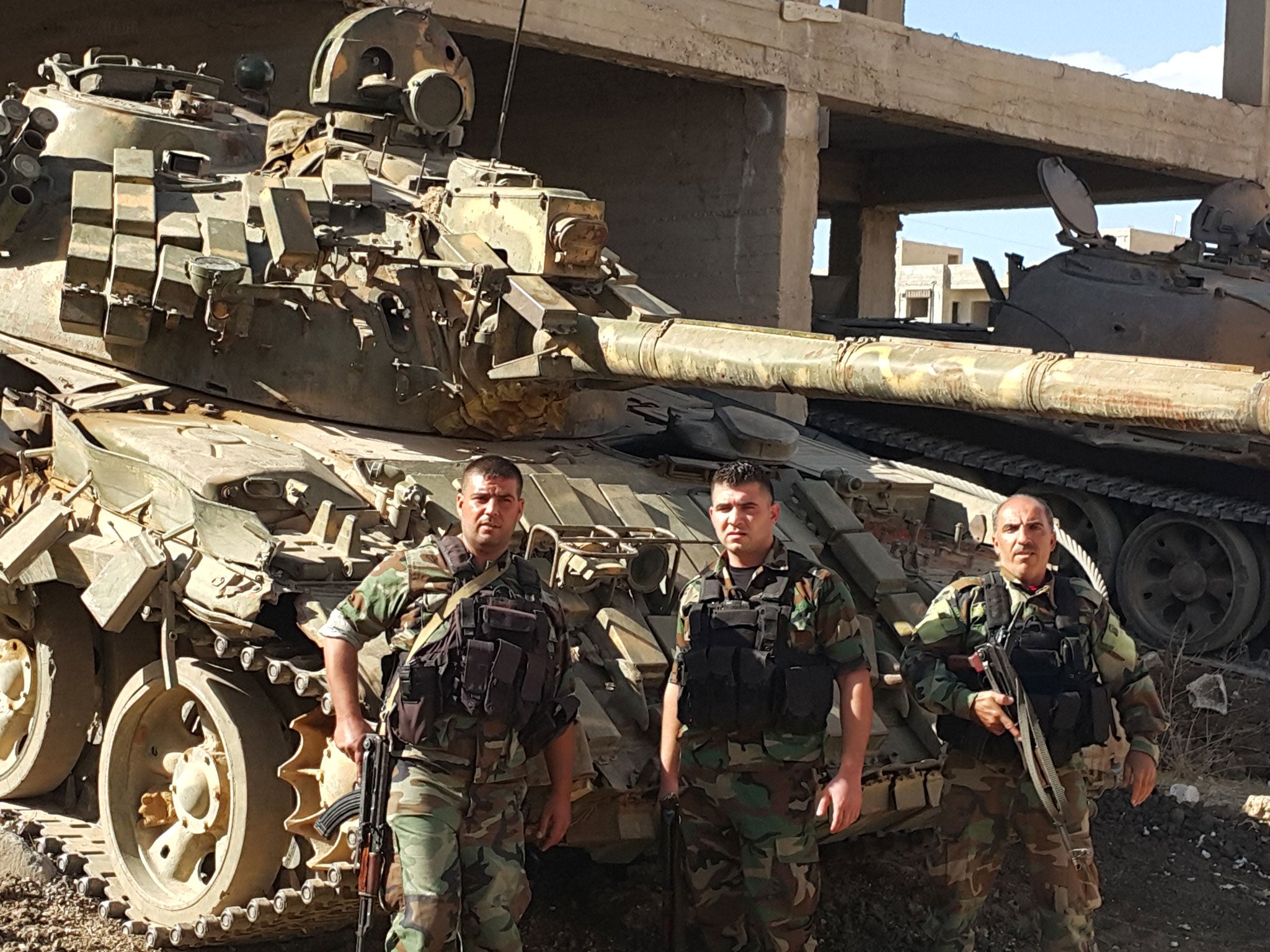 Syrian soldiers stand before their tanks at Quneitra, a few hundred metres from the front line with Nusrah Islamists and only five miles from Israeli troops on the Golan Heights