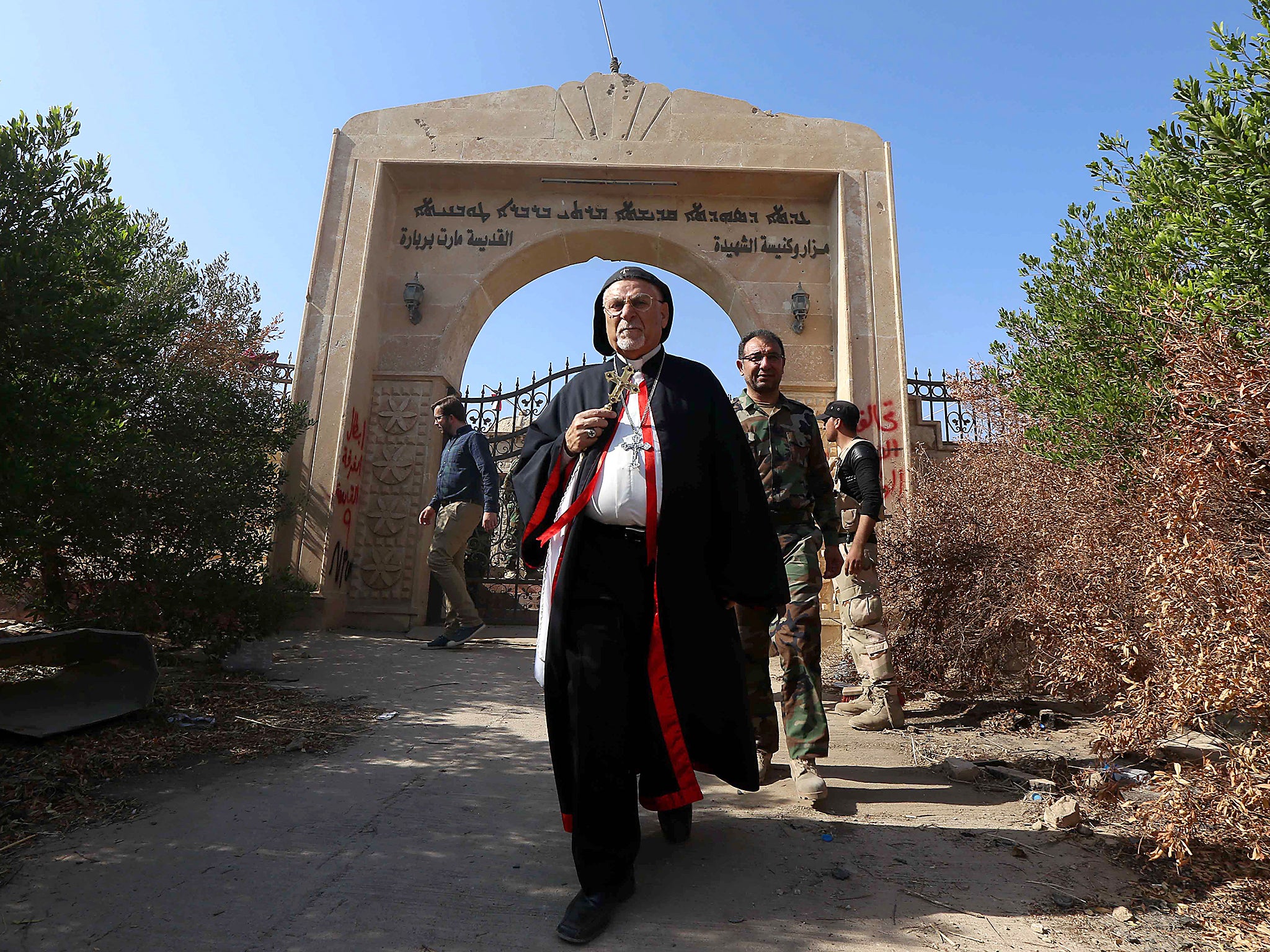 Archbishop Yohanna Petros Mouche of Mosul inspects the damage at the Saint Barbara Church in the town of Qaraqosh