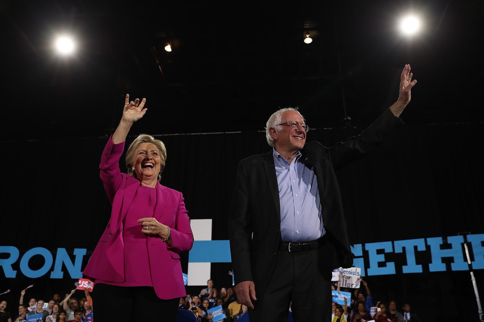 Democratic presidential nominee Hillary Clinton (L) and U.S. Sen Bernie Sanders (I-VT) greet supporters during a campaign rally at Coastal Credit Union Music Park at Walnut Creek on November 3, 2016 in Raleigh, North Carolina