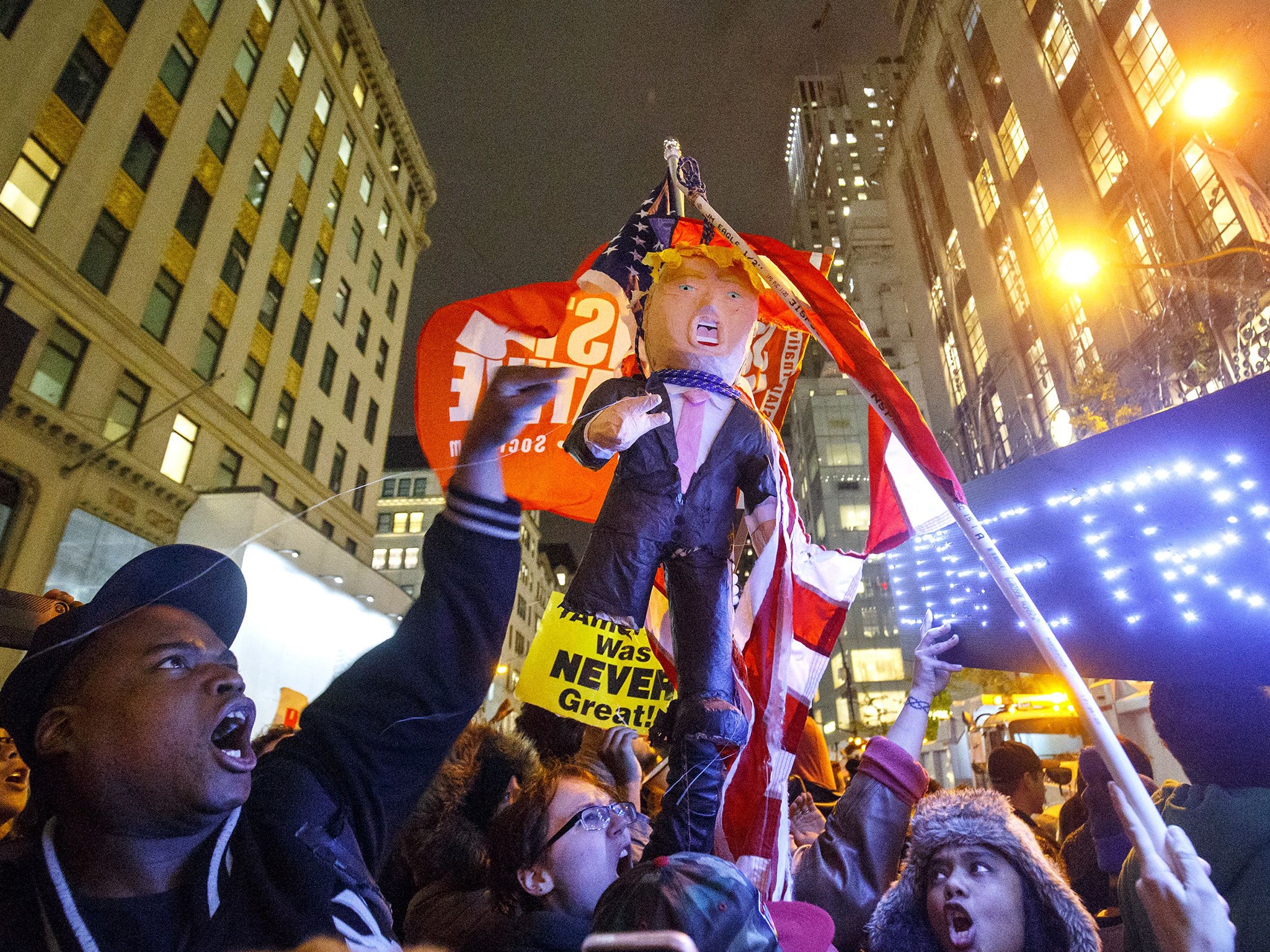 Thousands of anti-Trump demonstrators protest outside Trump Tower with a Donald Trump pinata after marching from Union Square in New York City