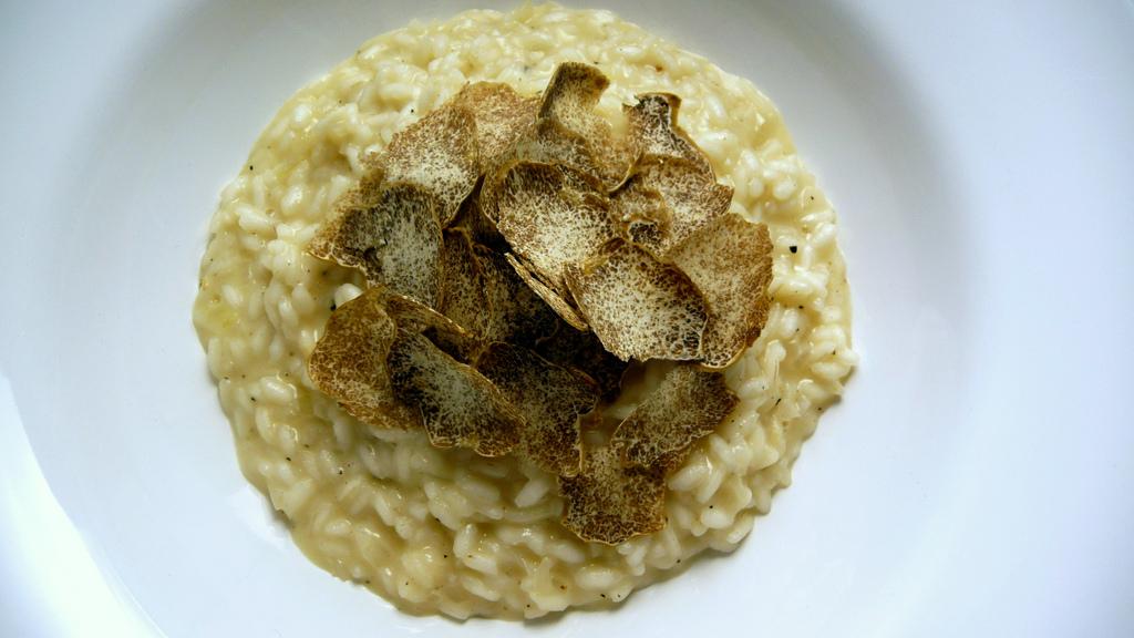 Some shaved truffle on top of a plate of creamy risotto