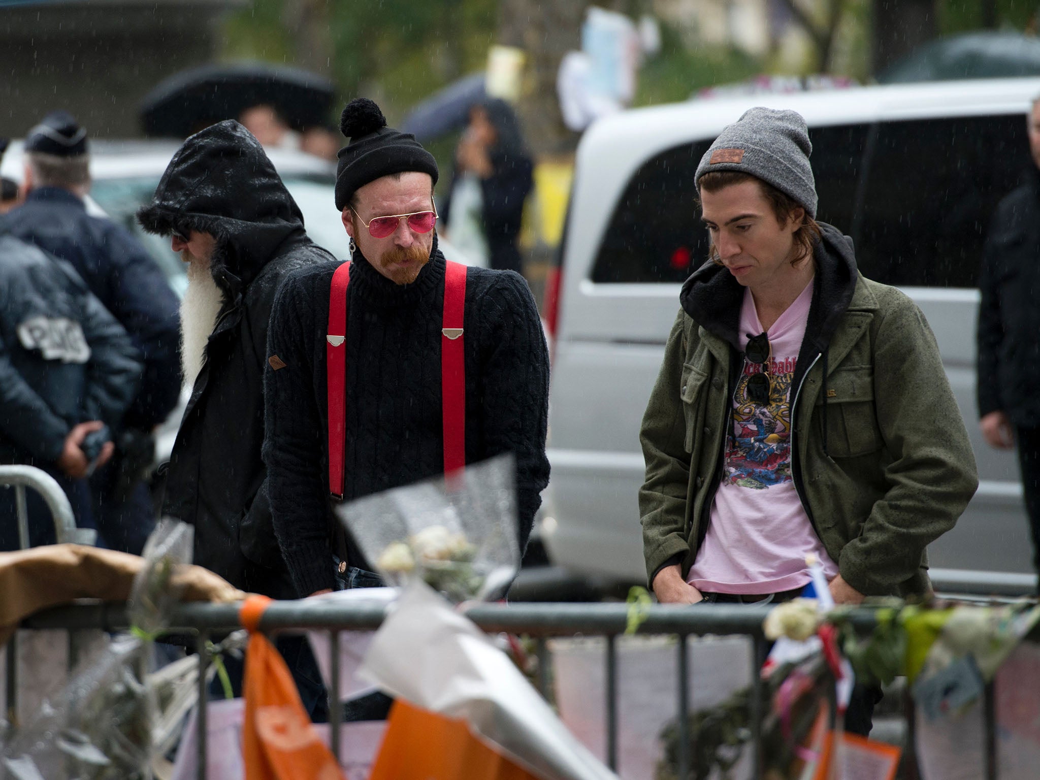 Jesse Hughes and Julian Dorio examine tributes to the victims of the attacks outside the Bataclan in December 2015