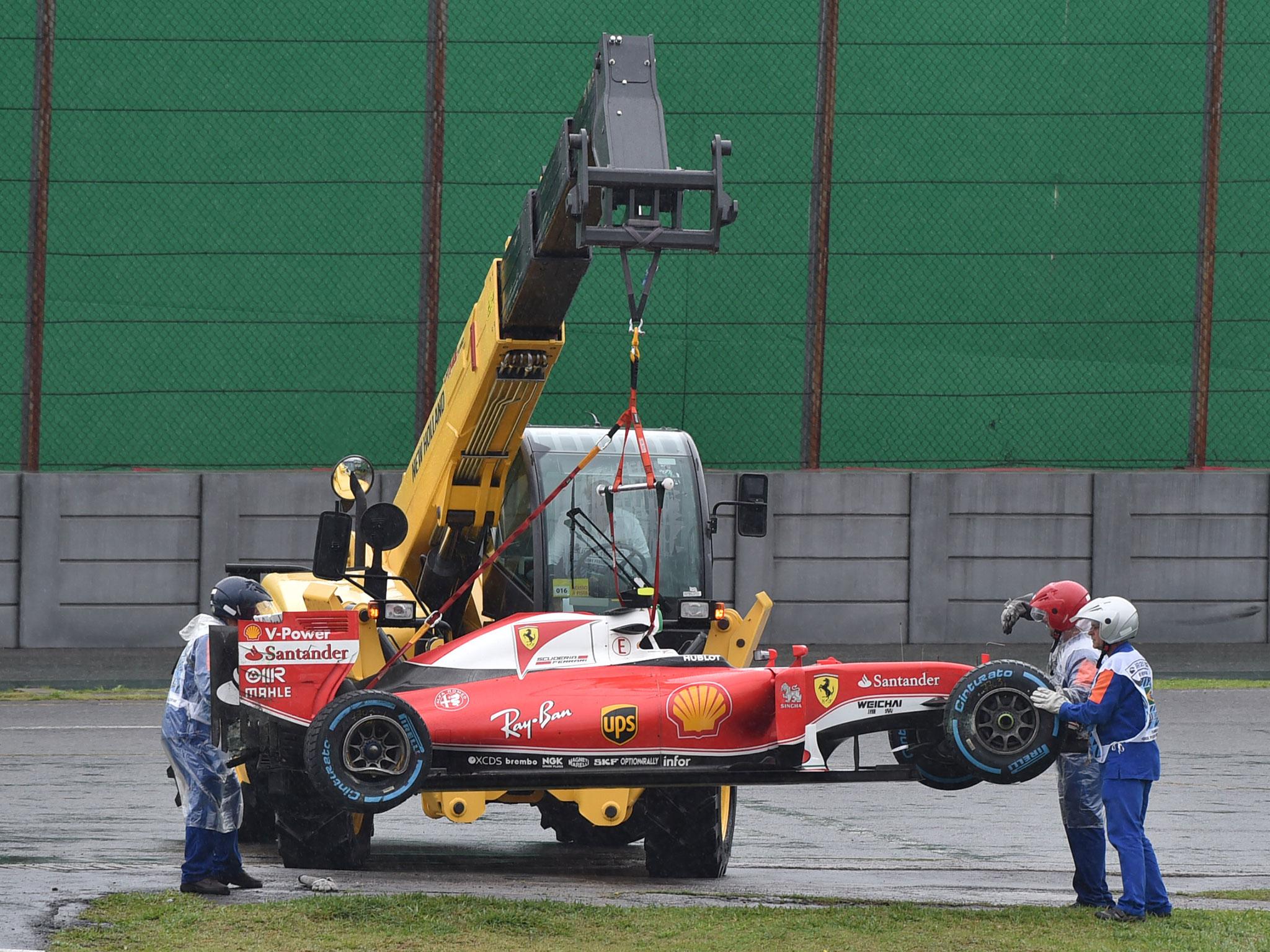 Kimi Raikkonen's stricken Ferrari is recovered after a heavy crash on the start-finish straight