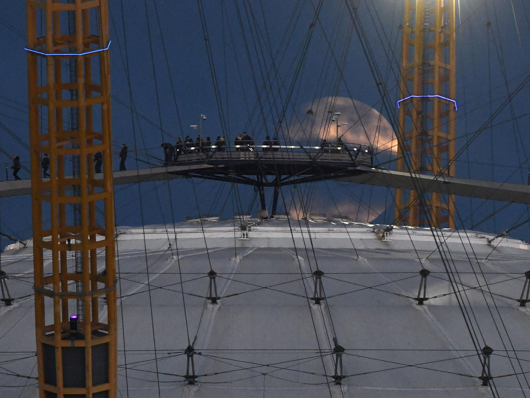 The moon rises over the O2 Arena in south-east London
