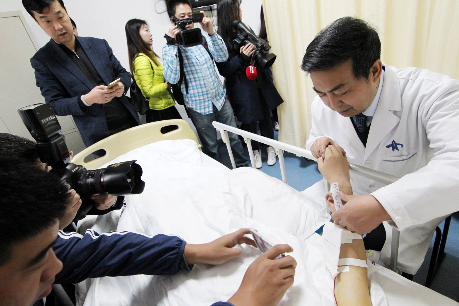 Reporters take pictures of an "ear" growing on the arm of a patient who lost his right ear in an accident, at the first affiliated hospital of Xi'an Jiaotong University, in Xi'an, Shaanxi province, China, November 9, 2016