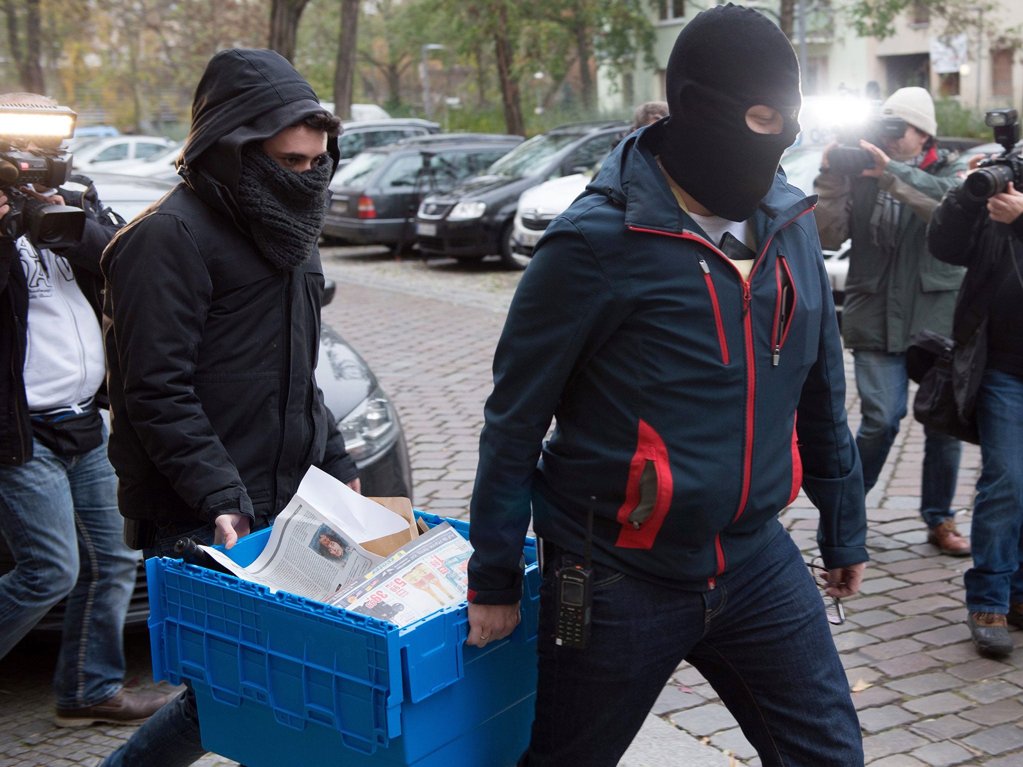 Police officers carry a case containing seized evidence during a counter-terror raid in Berlin, Germany, 15 November 2016