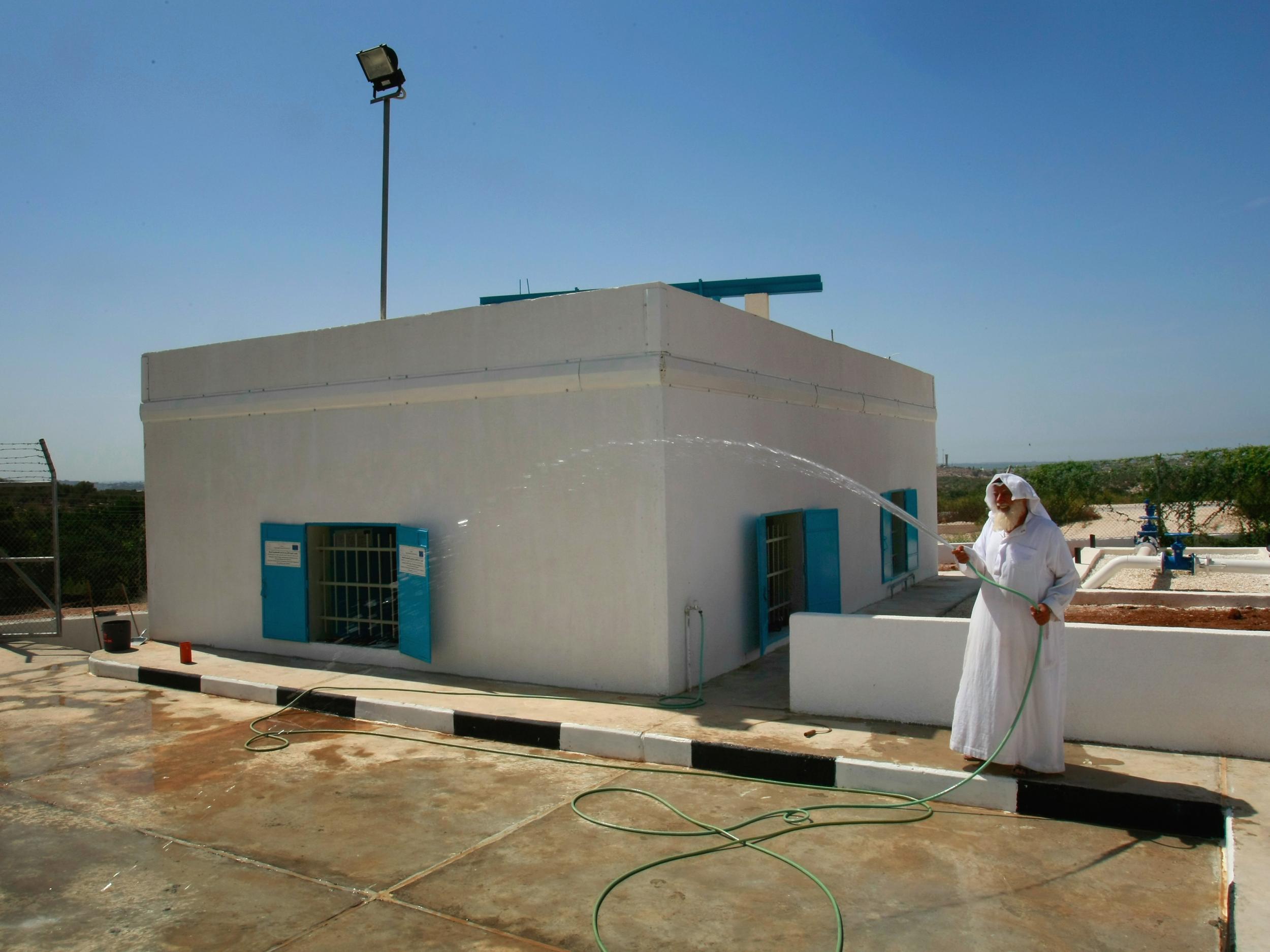 A caretaker tends to a renovated well in the West Bank