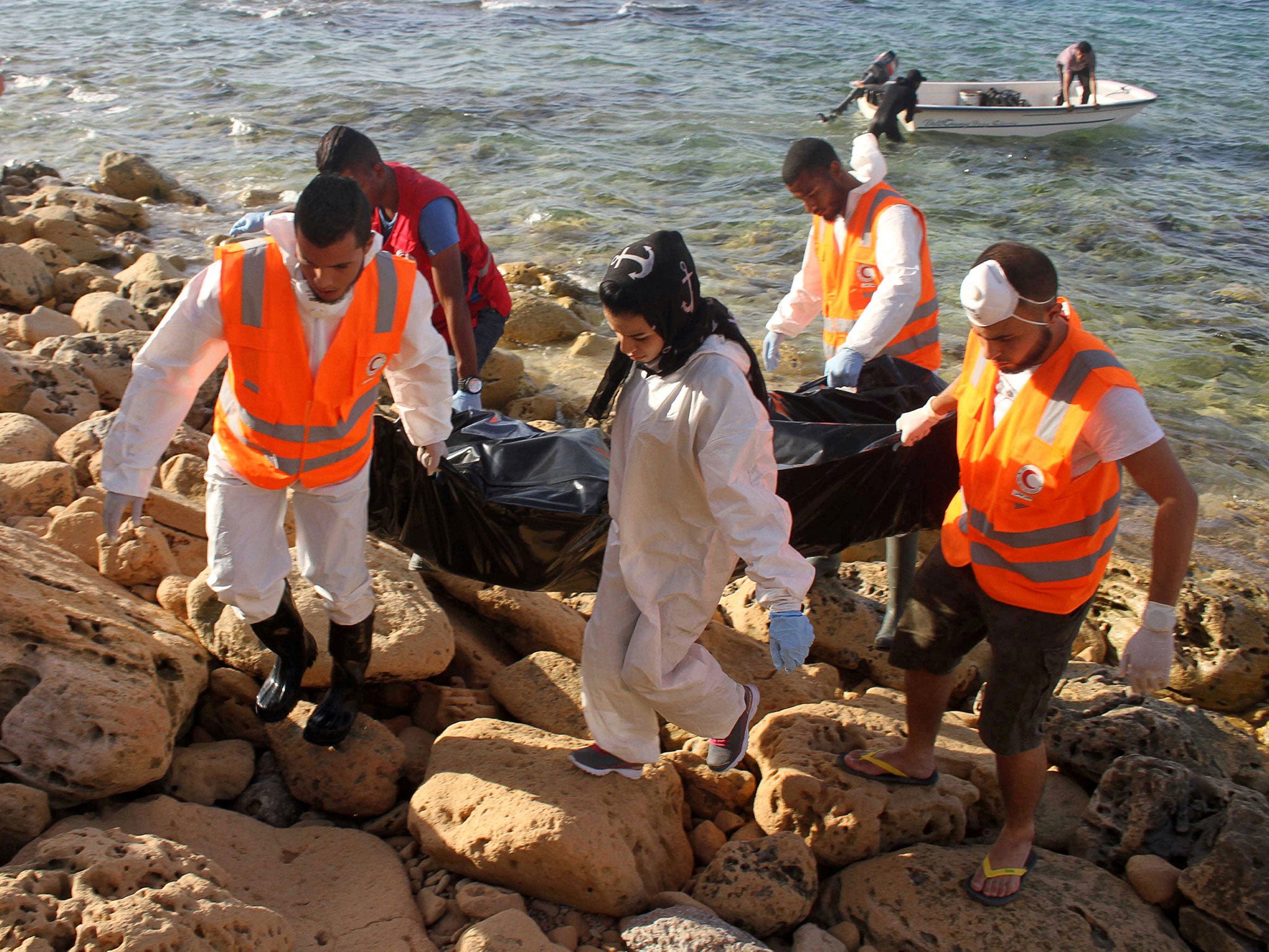 Rescue workers carry a bag containing the dead body of a migrant which washed ashore, in Tripoli's Janzour city, Libya November 5, 2016.