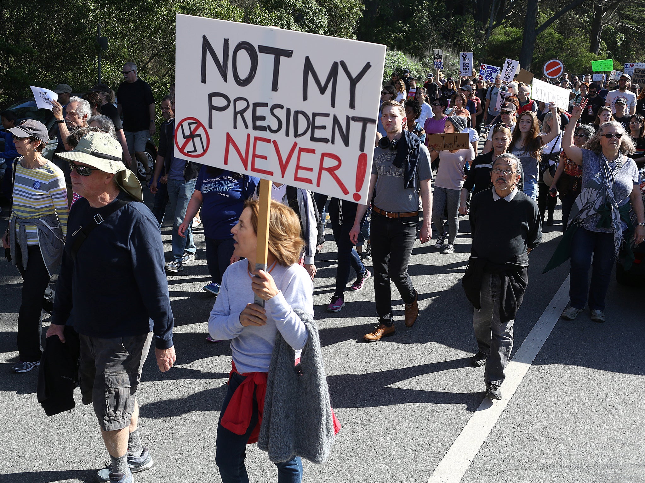 A woman holds a sign during a protest against President-elect Donald Trump at Golden Gate Park in San Francisco