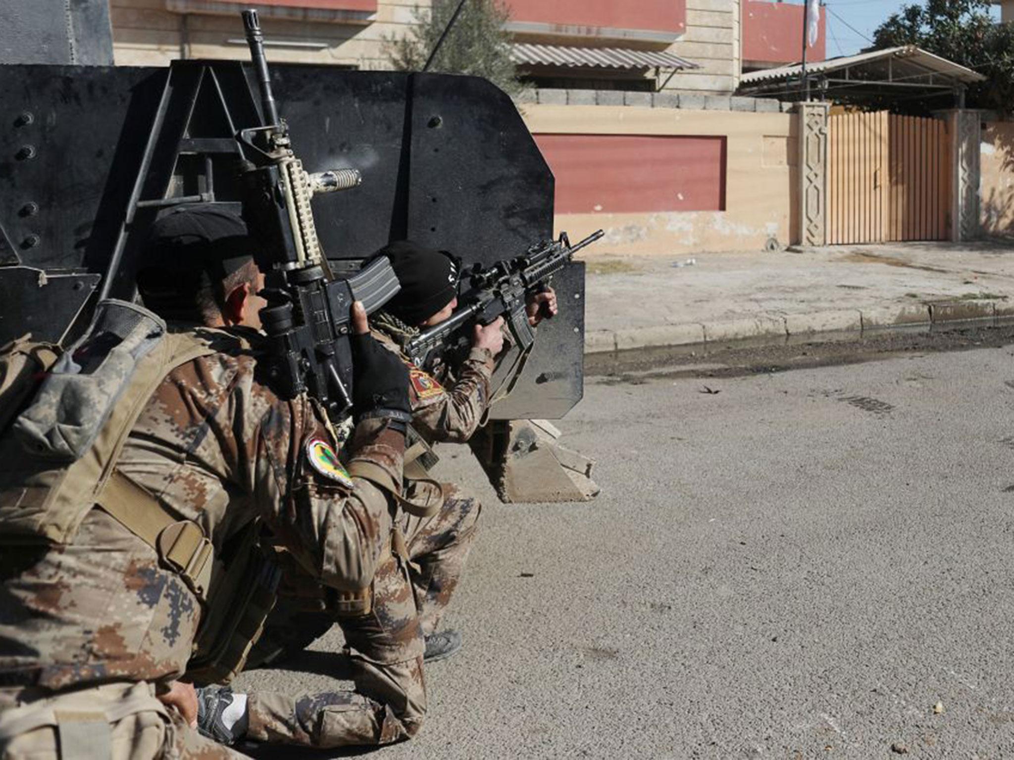 An Iraqi special forces soldier fires his rifle after an Islamic State suicide car bomb attack against Iraqi special forces during clashes in Mosul, Iraq on Saturday