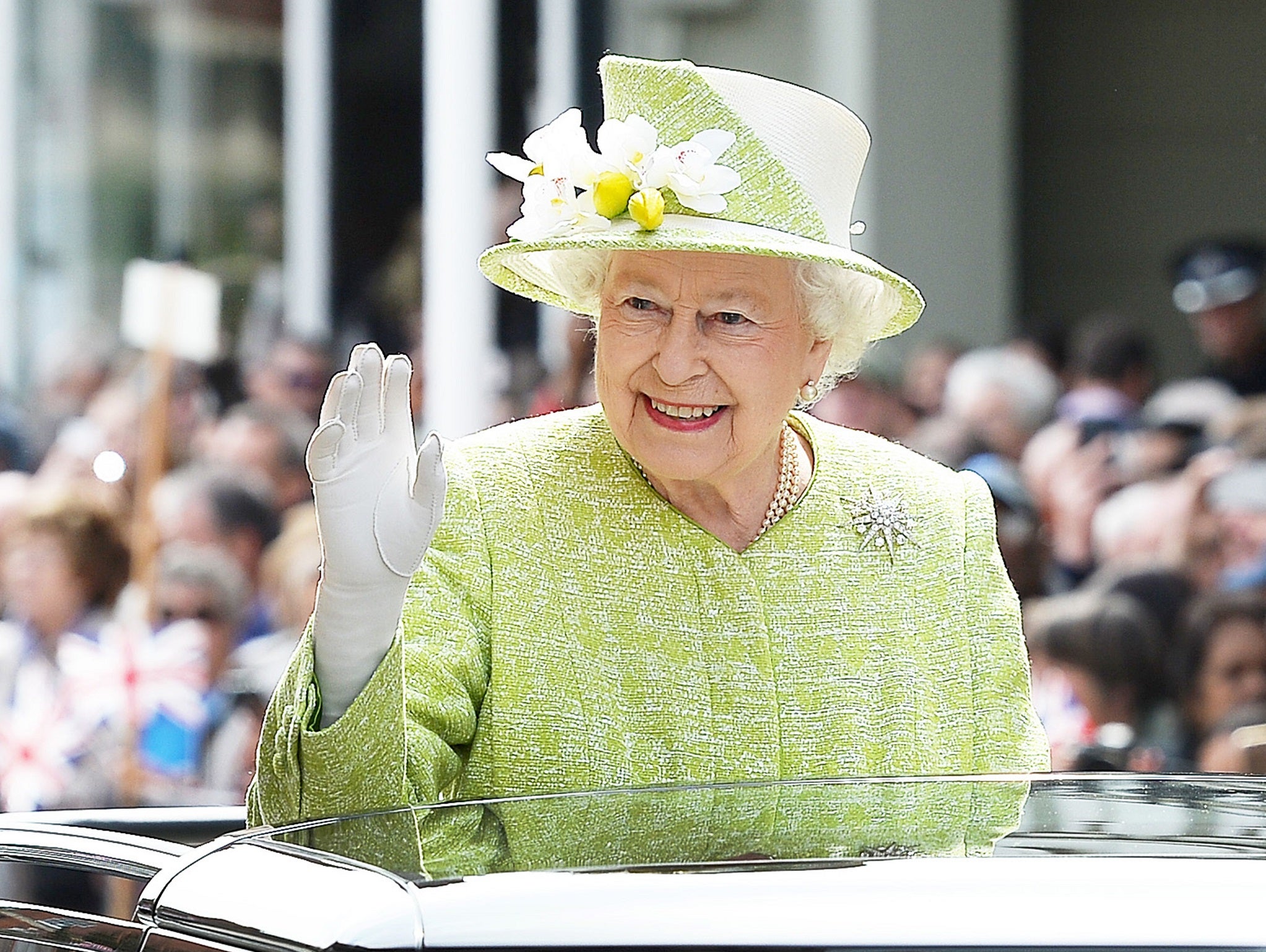 Queen Elizabeth II waves to wellwishers during a 'walkabout' on her 90th birthday in Windsor, west of London, on April 21, 2016