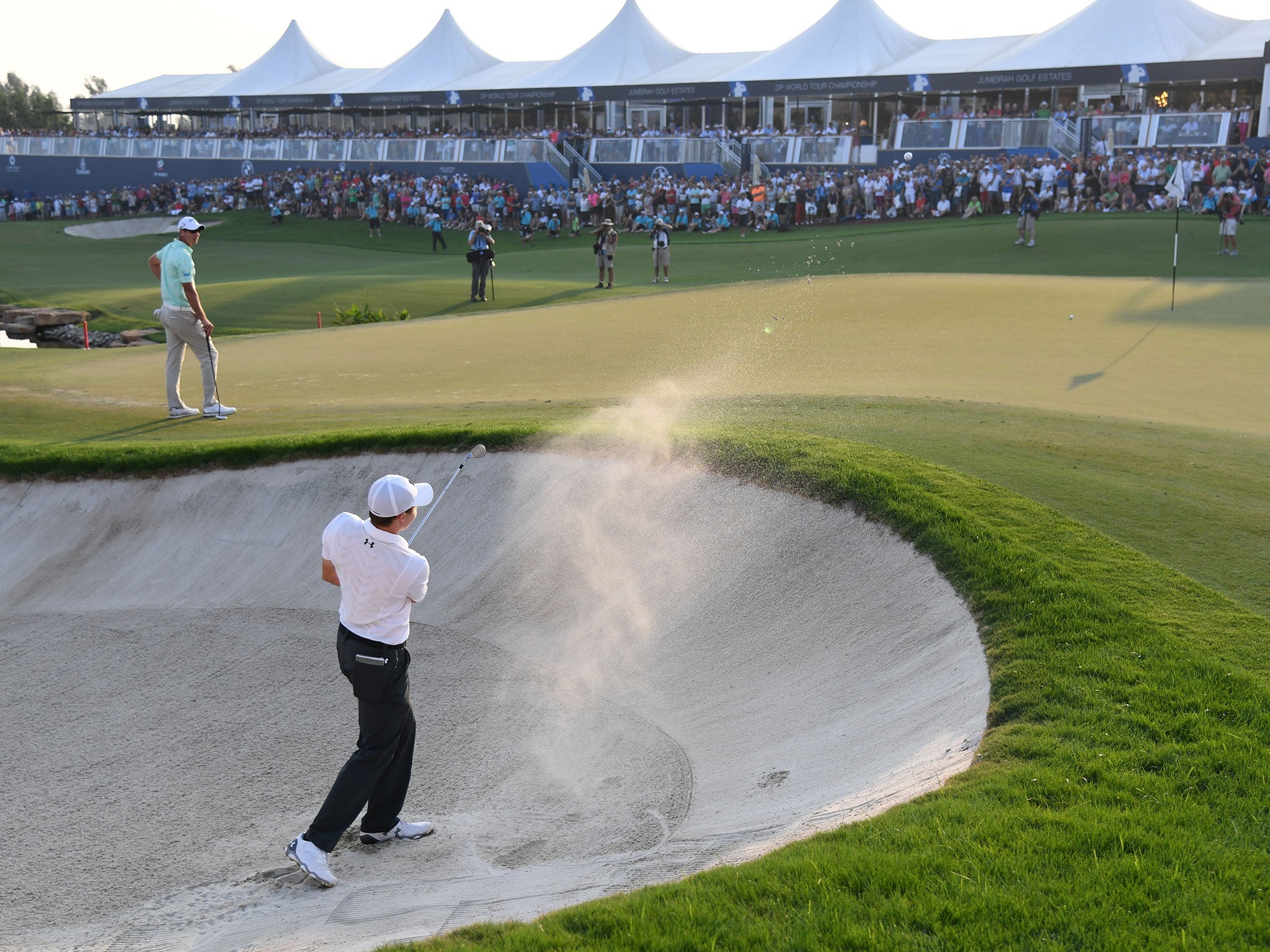 Fitzpatrick splashes out of a bunker on the 18th hole to find the green