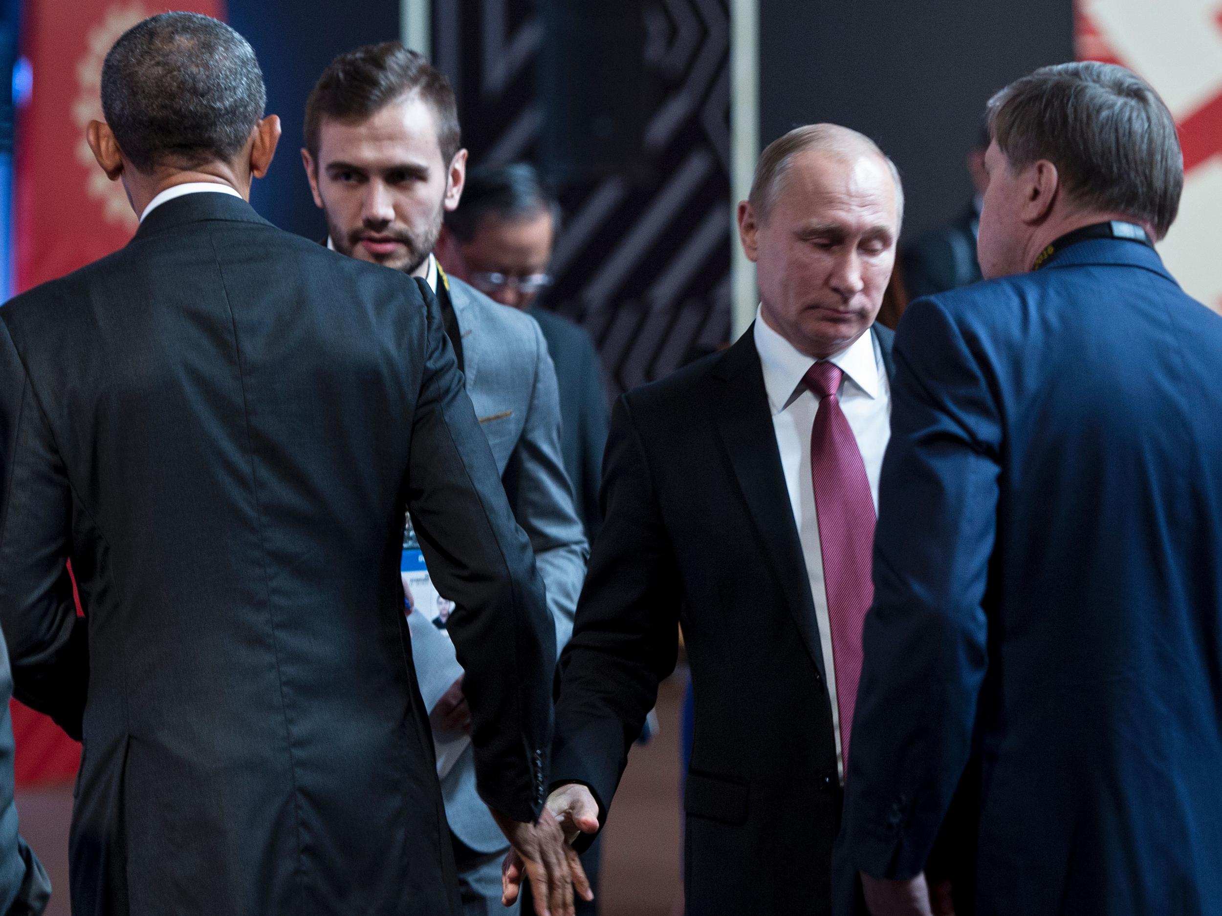 US President Barack Obama (L) and Russia's President Vladimir Putin (2R) walk from each other after speaking and shaking hands before an economic leaders meeting