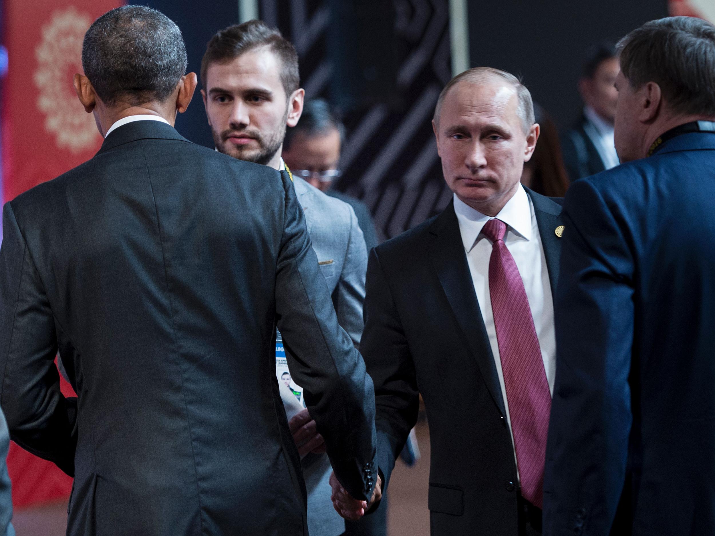 US President Barack Obama (L) and Russia's President Vladimir Putin (2nd-R) shake hands before an economic leaders meeting at the Asia-Pacific Economic Cooperation Summit