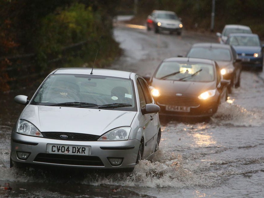 Cars drive on a flooded street outside Port Talbot, south Wales