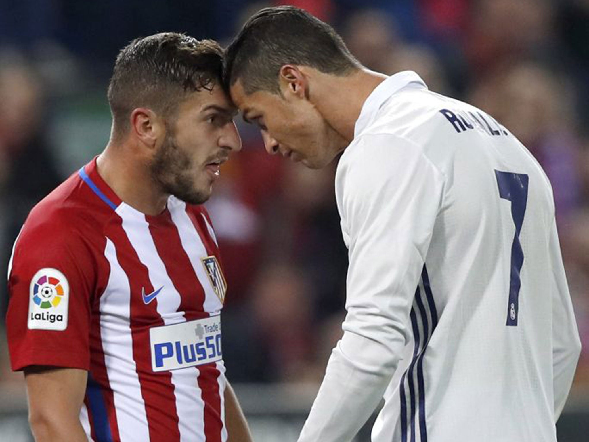 Koke and Cristiano Ronaldo clash during the Madrid derby between Real and Atletico