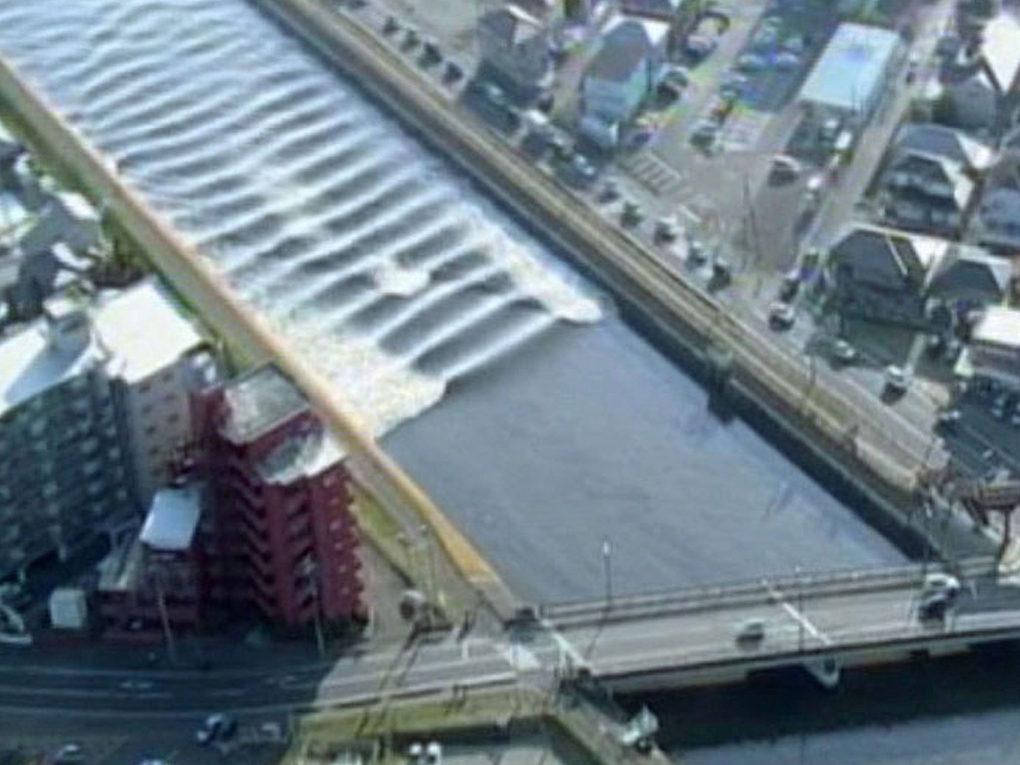 A tidal surge is seen in Sunaoshi River after tsunami advisories were issued following an earthquake in Tagajo