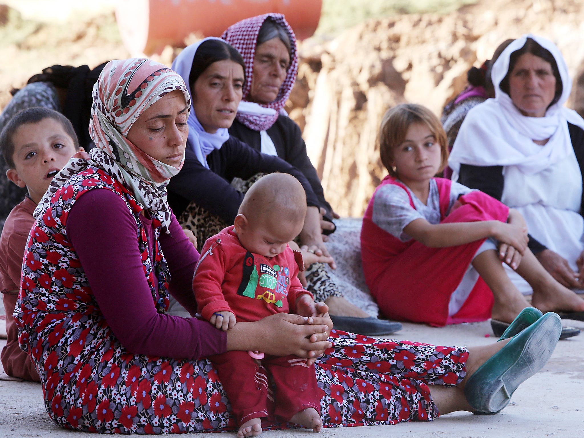 Iraqi Yazidis, who fled their homes when Isis militants attacked the town of Sinjar, gather inside a building under construction where they found refuge