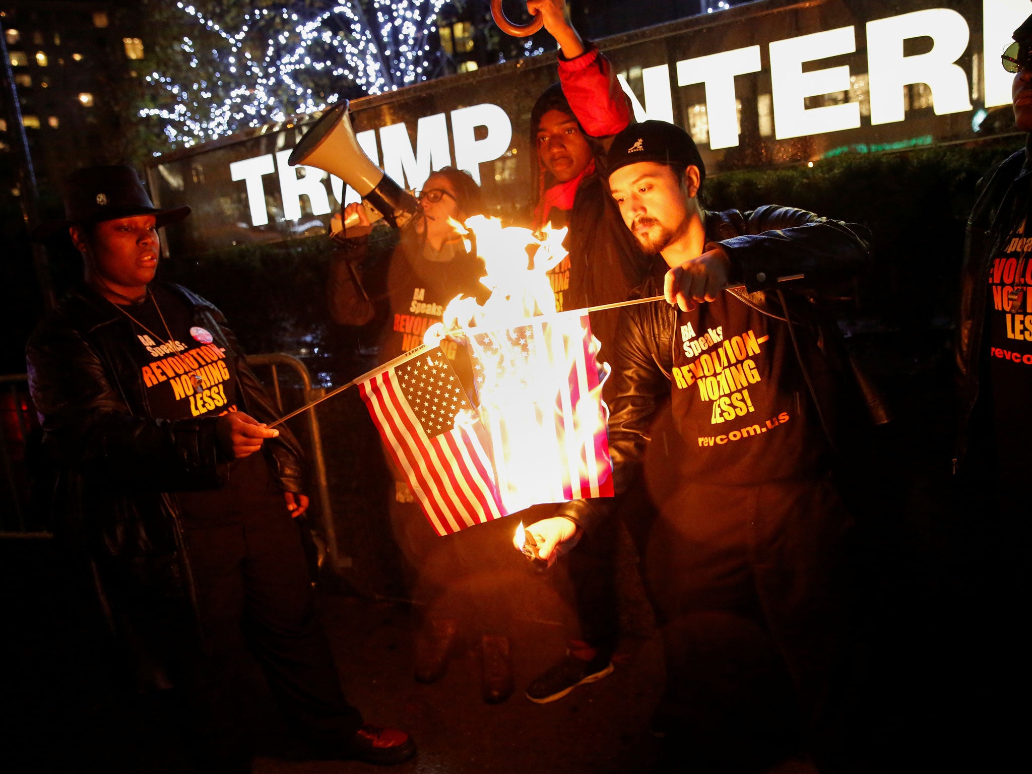 Supporters of the 'NYC Revolution Club' burn the US flag outside the Trump International Hotel and Tower