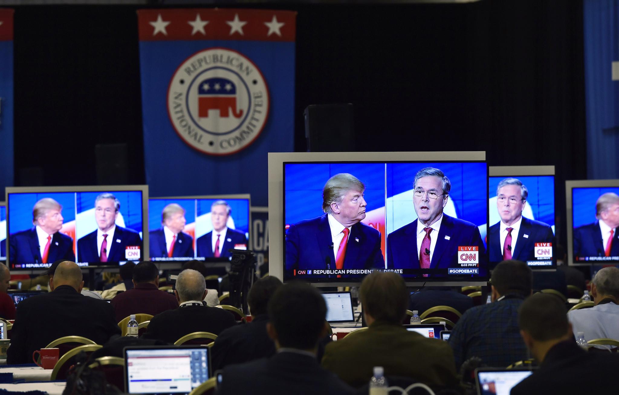 Republican U.S. presidential candidates businessman Donald Trump and former Governor Jeb Bush are seen debating on video monitors in the press room during the Republican presidential debate in Las Vegas